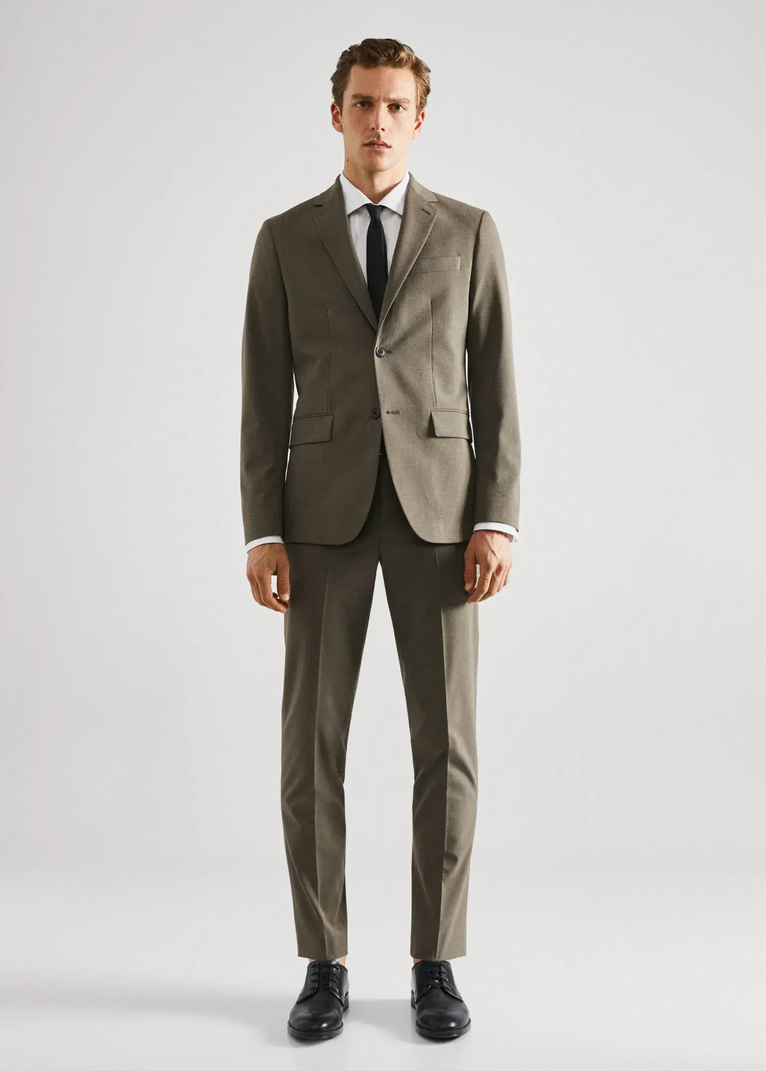 Mango Stretch fabric slim-fit suit pants. a man wearing a suit and tie standing in a room. 