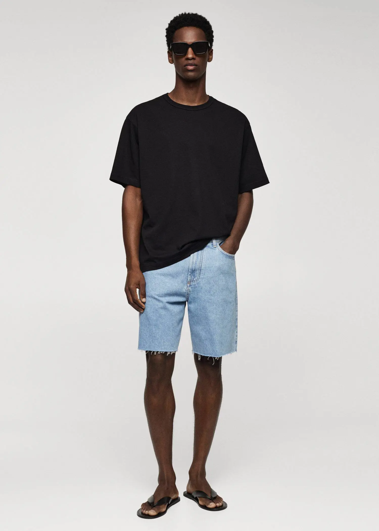 Mango 100% cotton relaxed-fit t-shirt. a man in black shirt and blue denim shorts. 