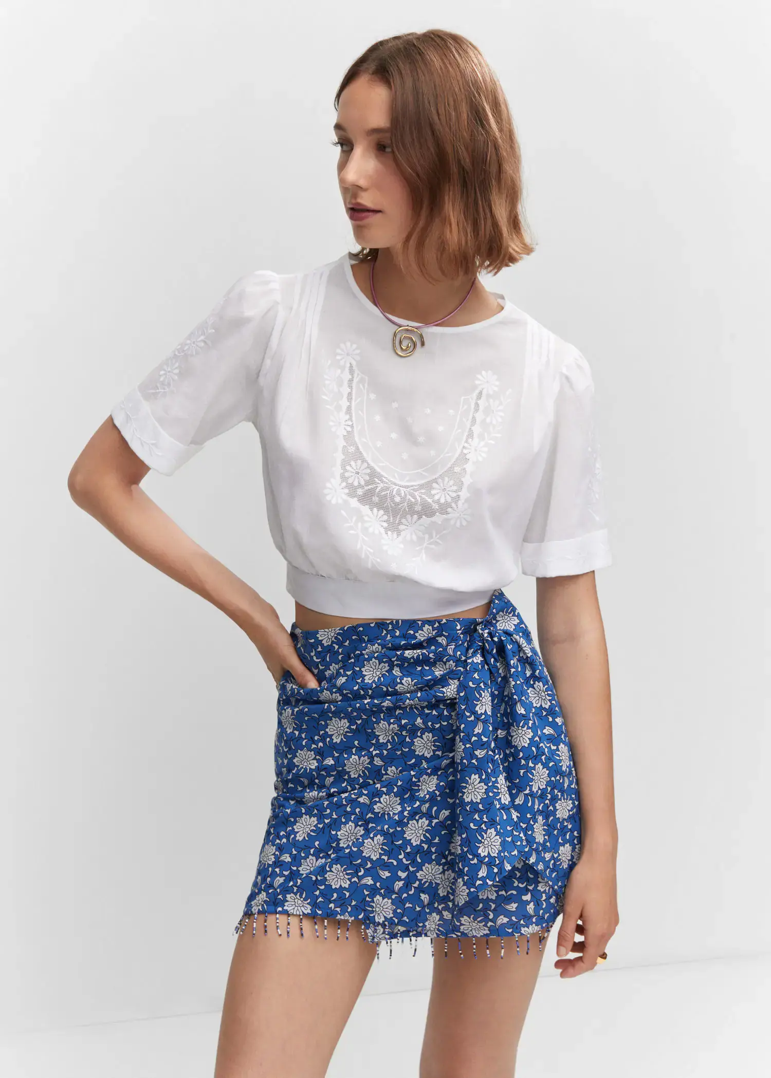 Mango Embroidered crop top. a woman wearing a white shirt and blue skirt. 