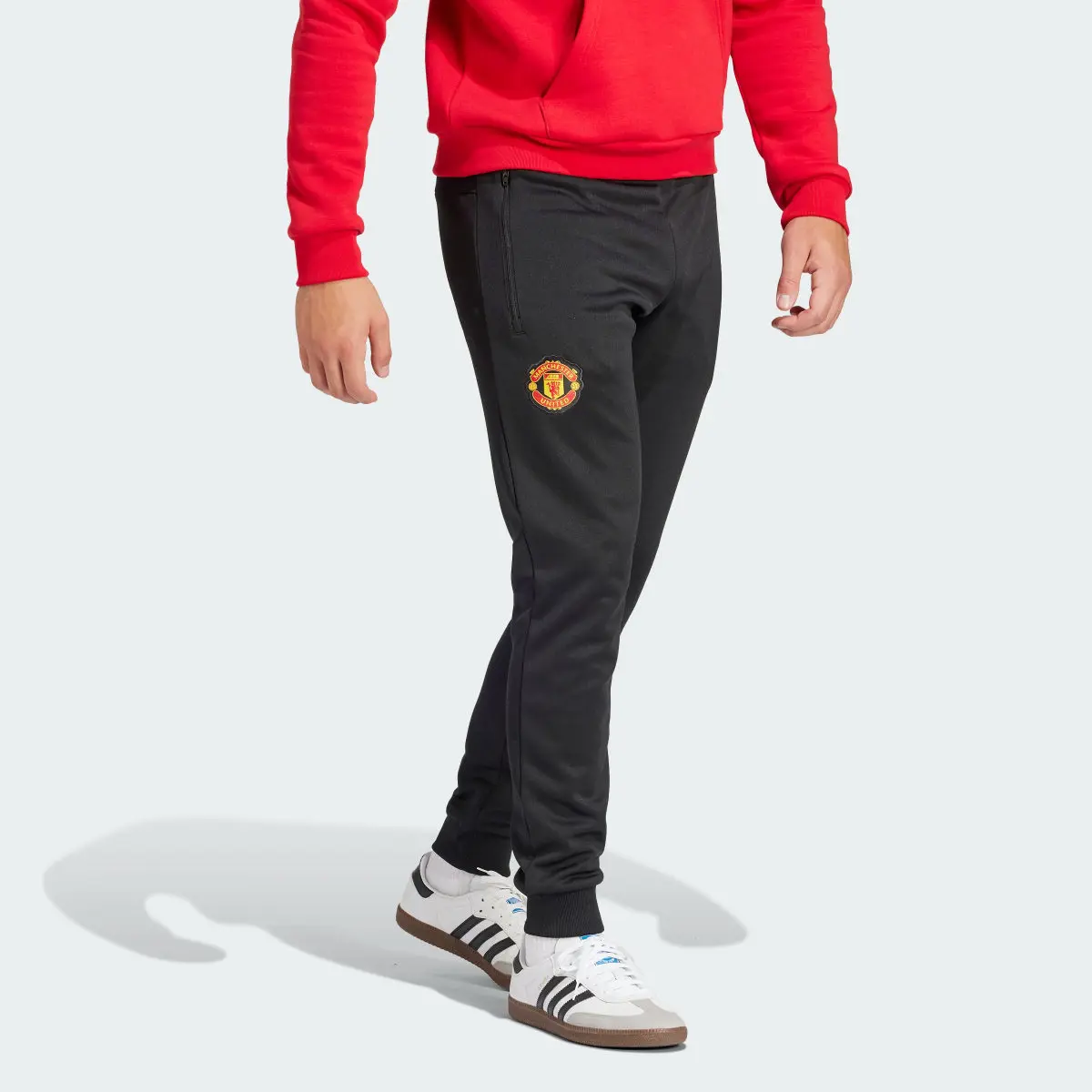 Adidas Spodnie dresowe Manchester United Essentials Trefoil. 1