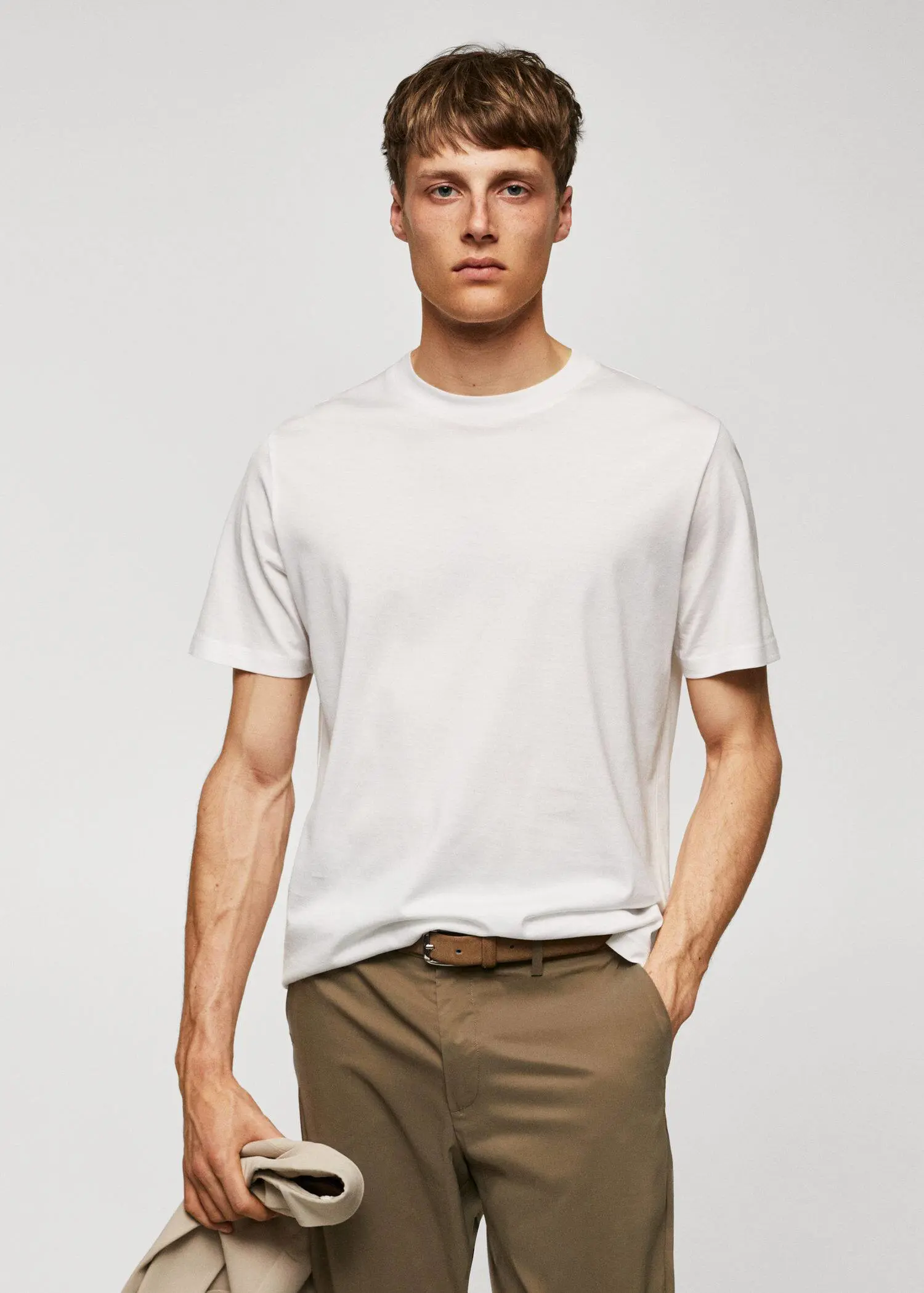 Mango Mercerised regular-fit t-shirt. a man in a white t-shirt is standing with his hands in his pockets 