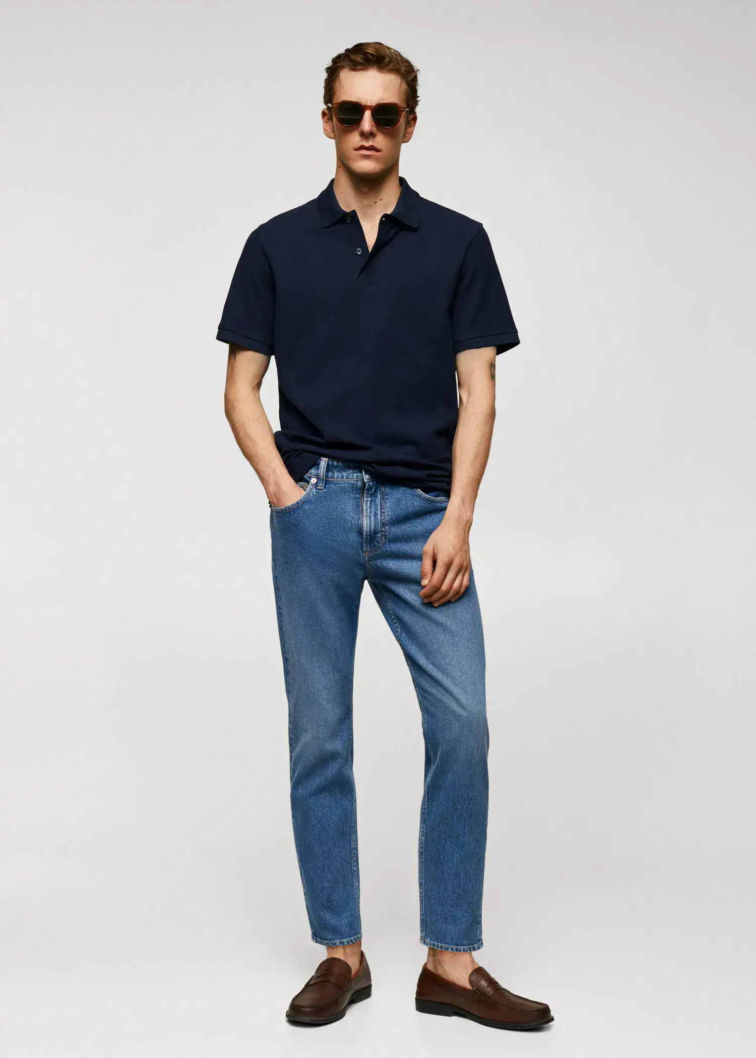 Mango 100% cotton pique polo shirt. a man in a black polo shirt and blue jeans. 