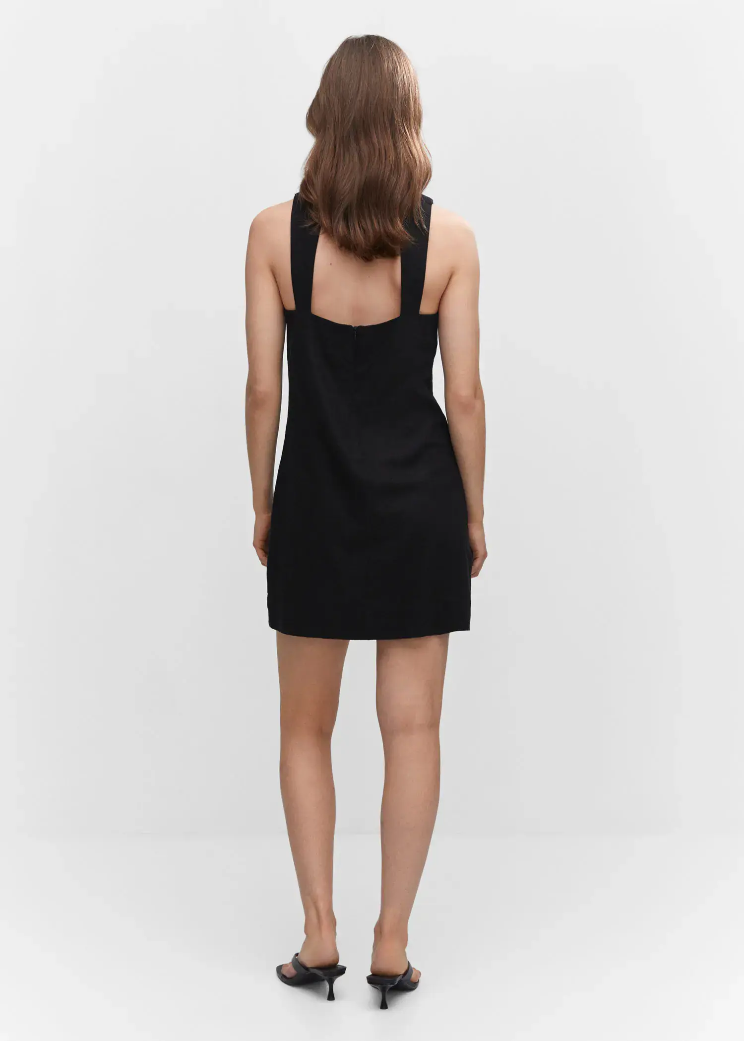 Mango Linen dress with back opening. a woman wearing a black dress standing in front of a wall. 