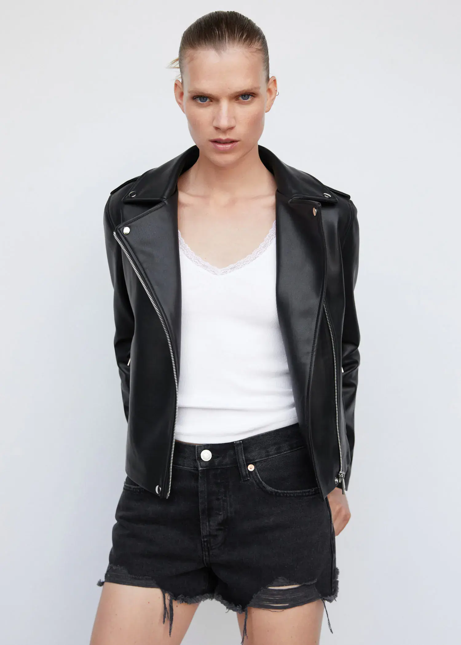 Mango Faux-leather biker jacket. a woman wearing a black leather jacket and jeans. 