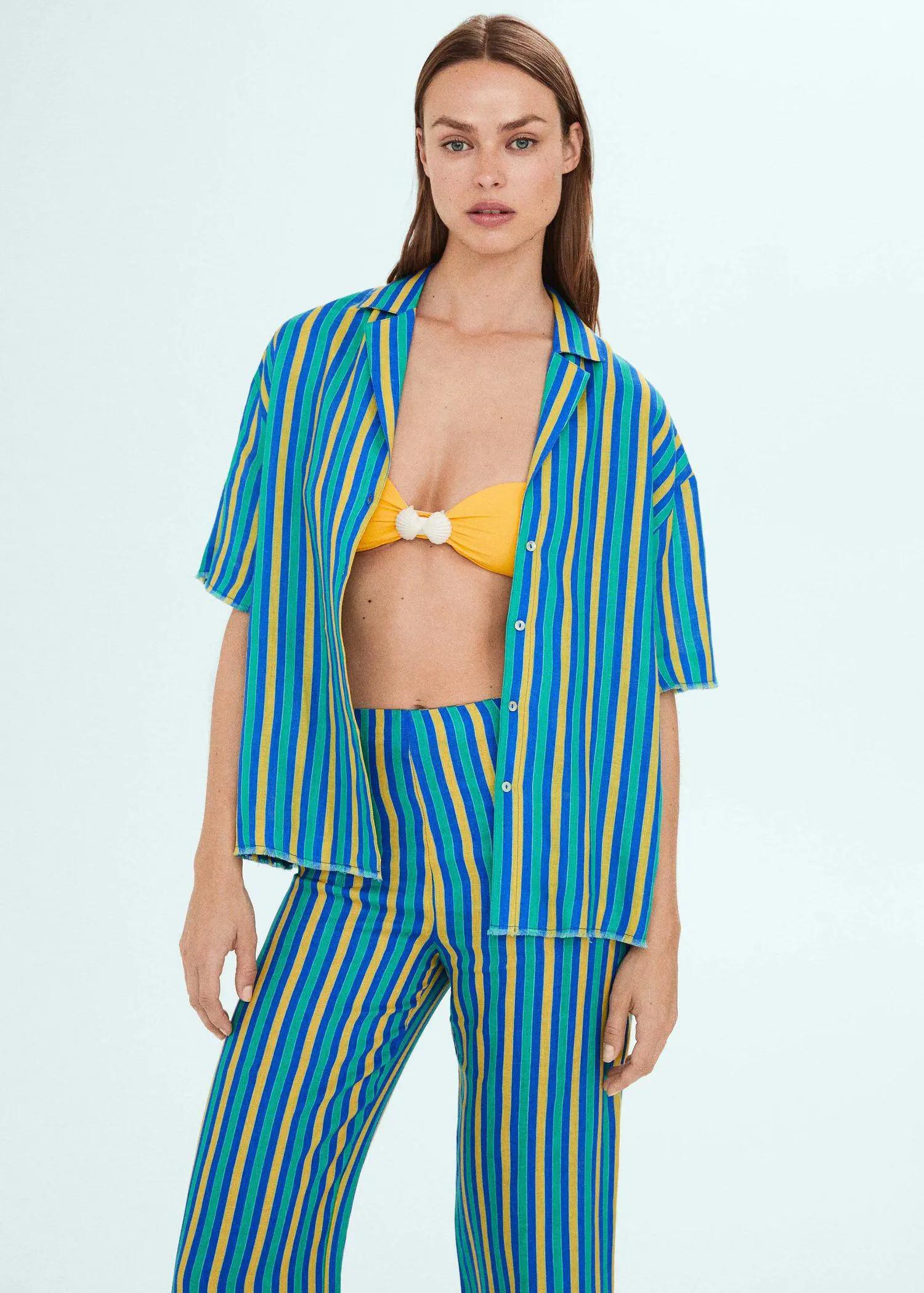 Mango Multi-colored striped linen shirt. a woman in a blue and yellow striped outfit. 