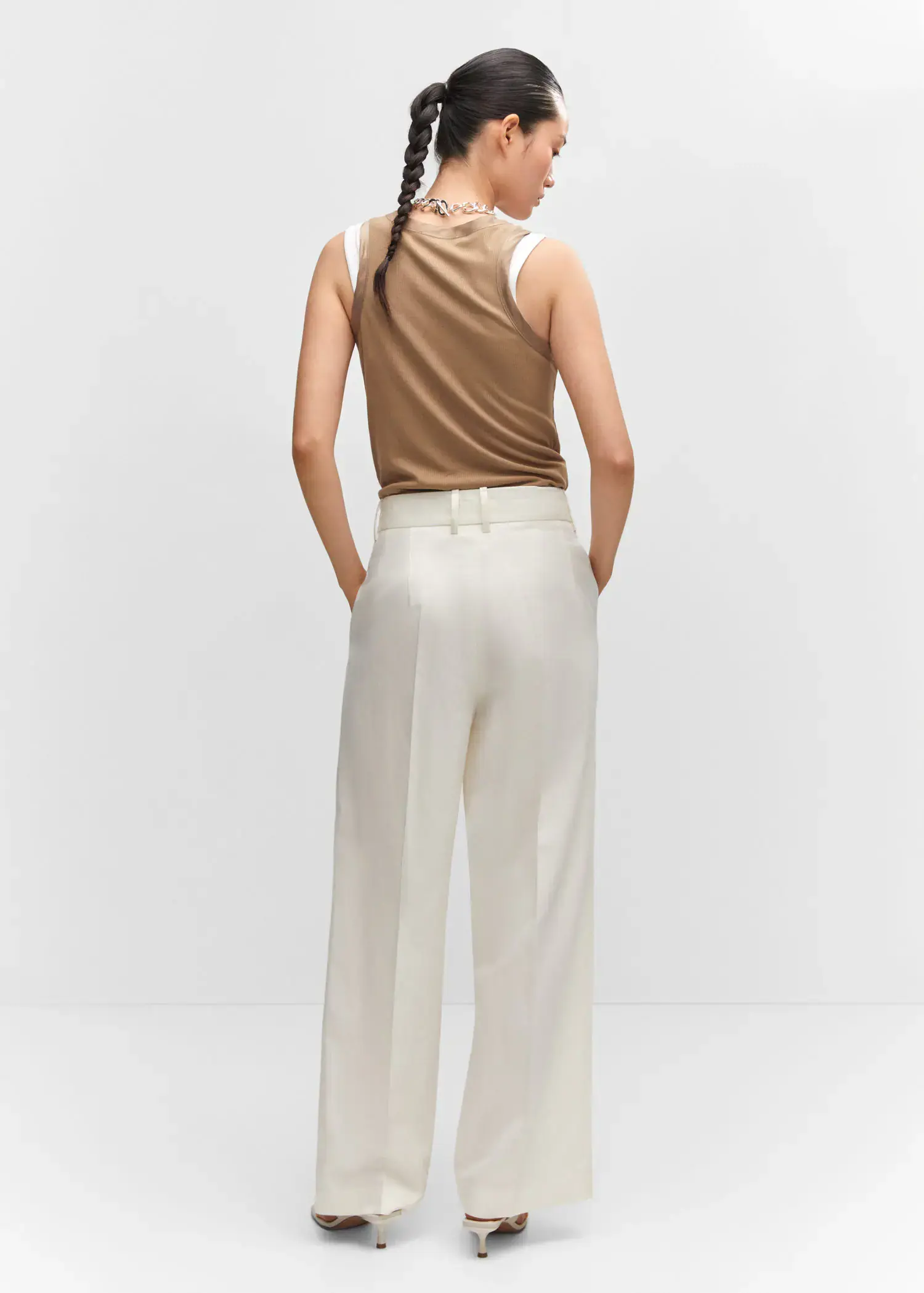 Mango Wideleg pleated pants. a woman in a tan tank top and white pants. 