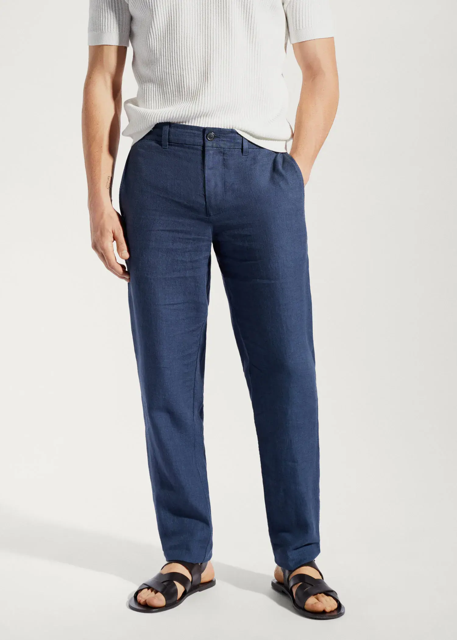 Mango Slim-fit 100% linen trousers. a man standing in front of a white wall. 