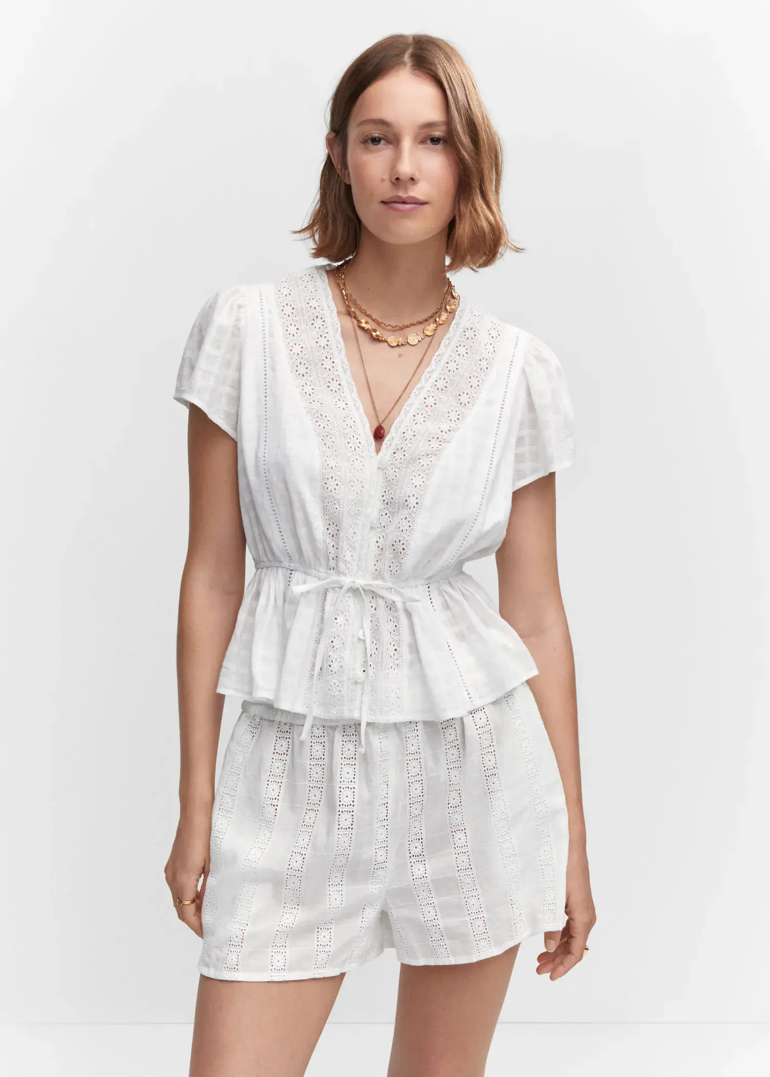 Mango Embroidered openwork blouse. a woman in a white outfit is posing for a picture. 
