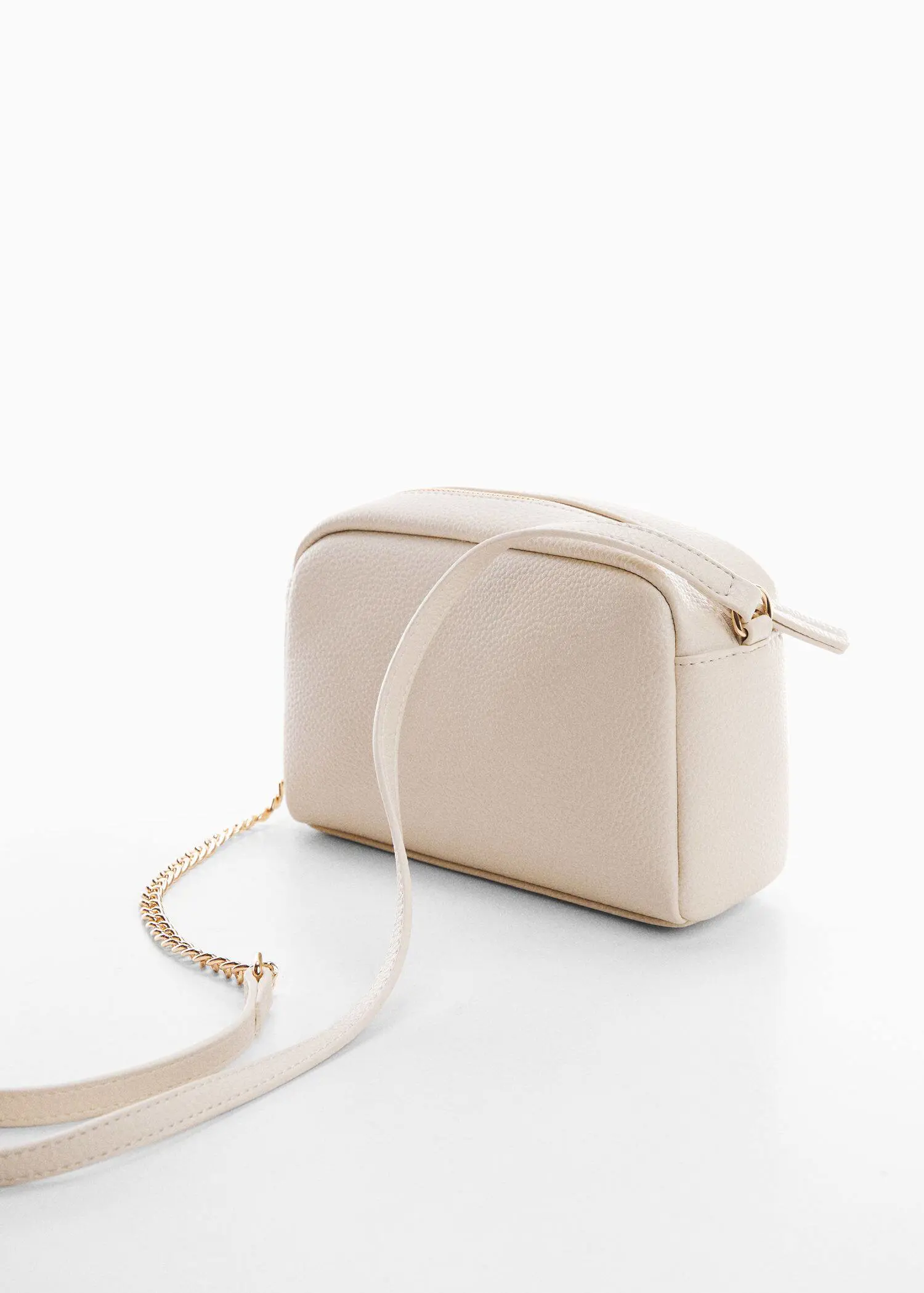 Mango Crossbody bag with chain. a white purse is sitting on a table. 