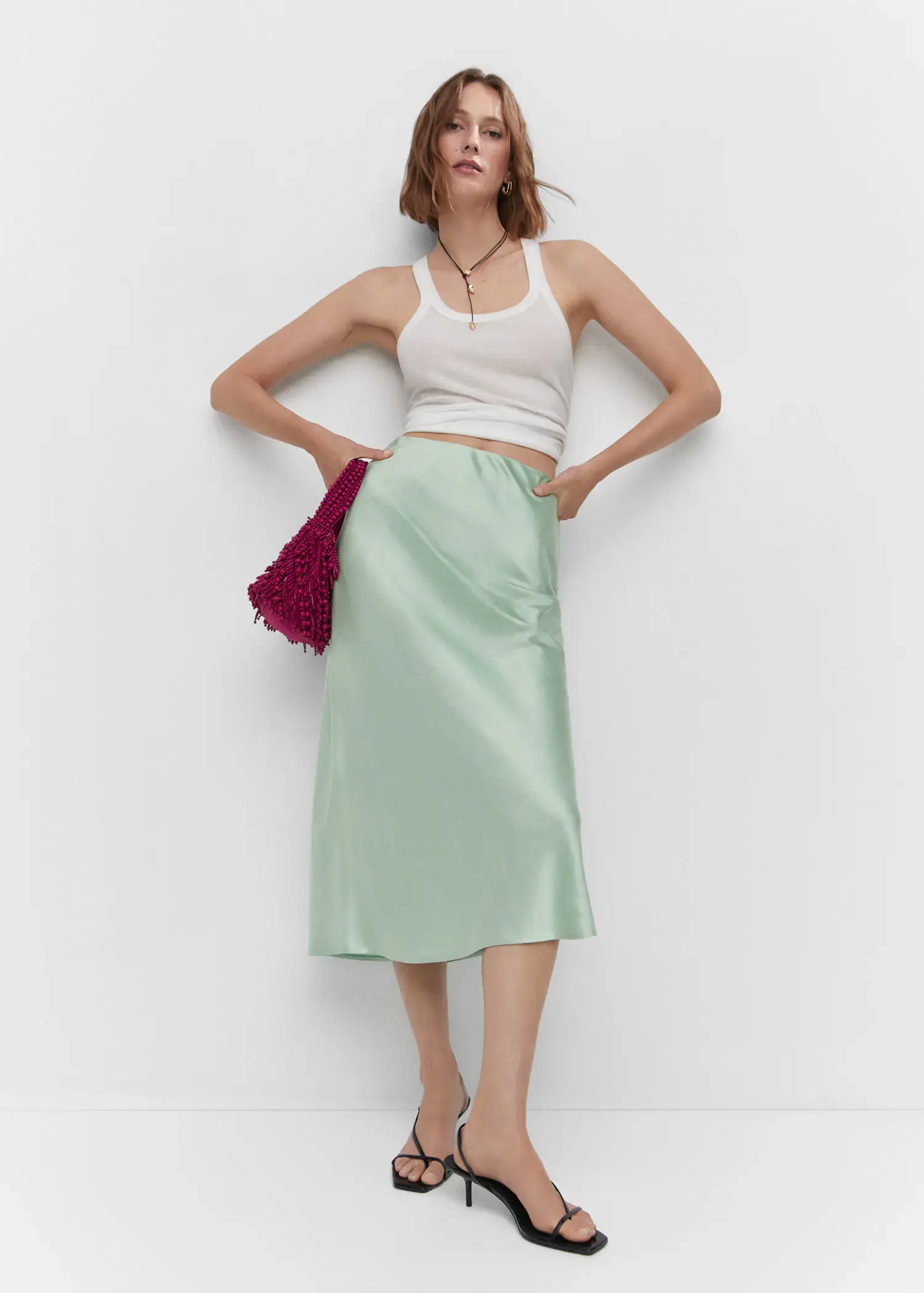 Mango Midi satin skirt. a woman standing in front of a white wall. 