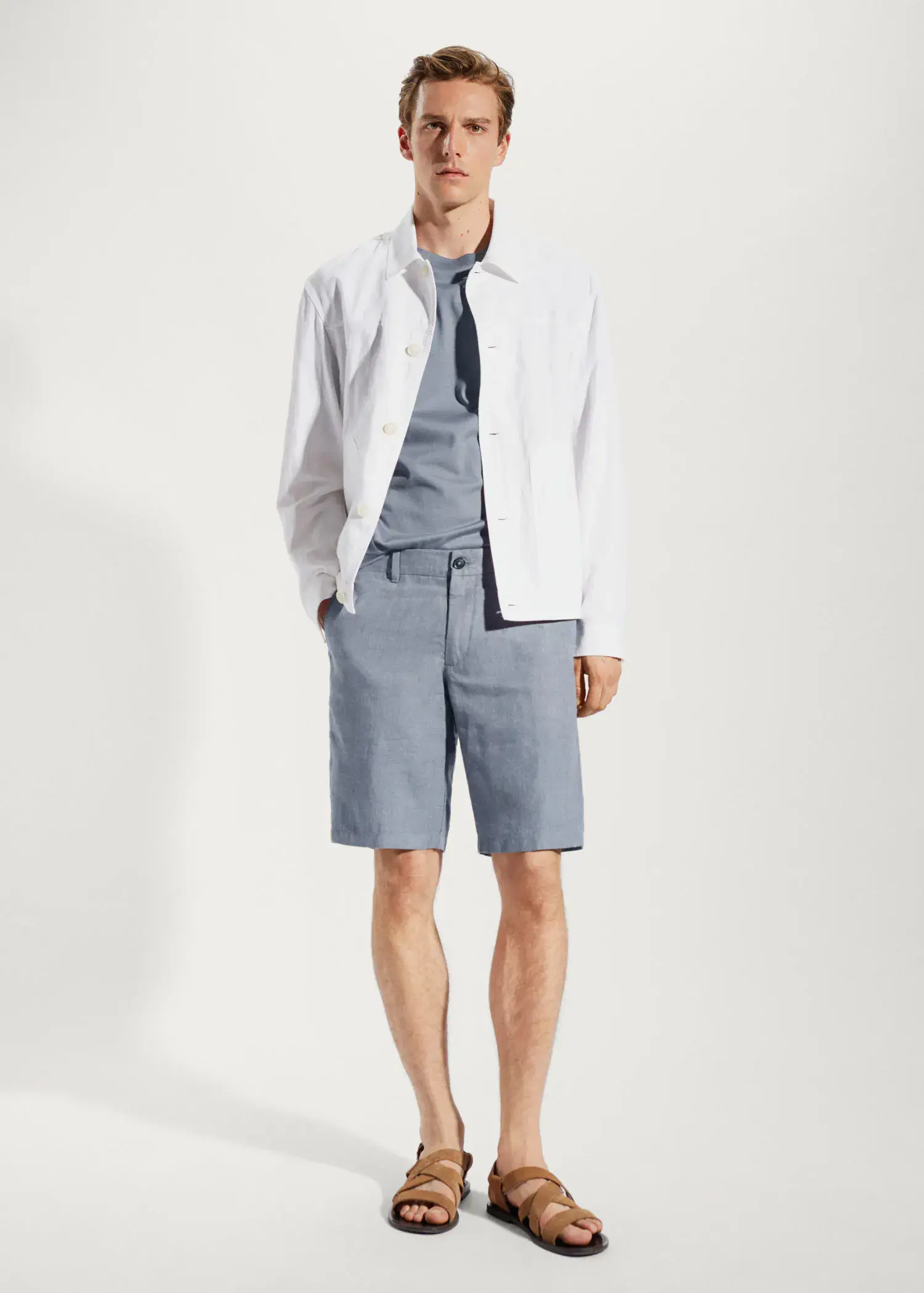 Mango 100% linen shorts. a man in a white shirt and blue shorts. 