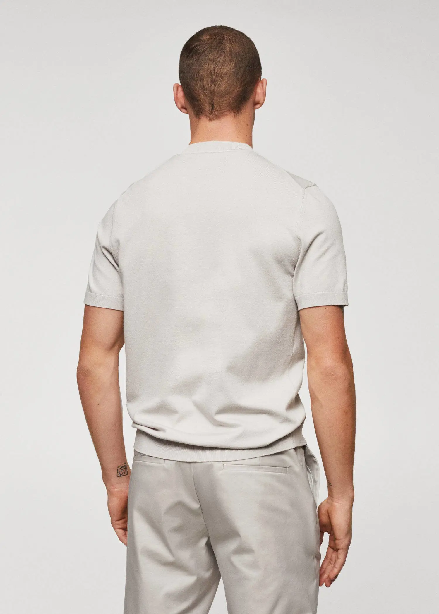 Mango Fine-knit T-shirt. a man wearing a white shirt and gray pants. 