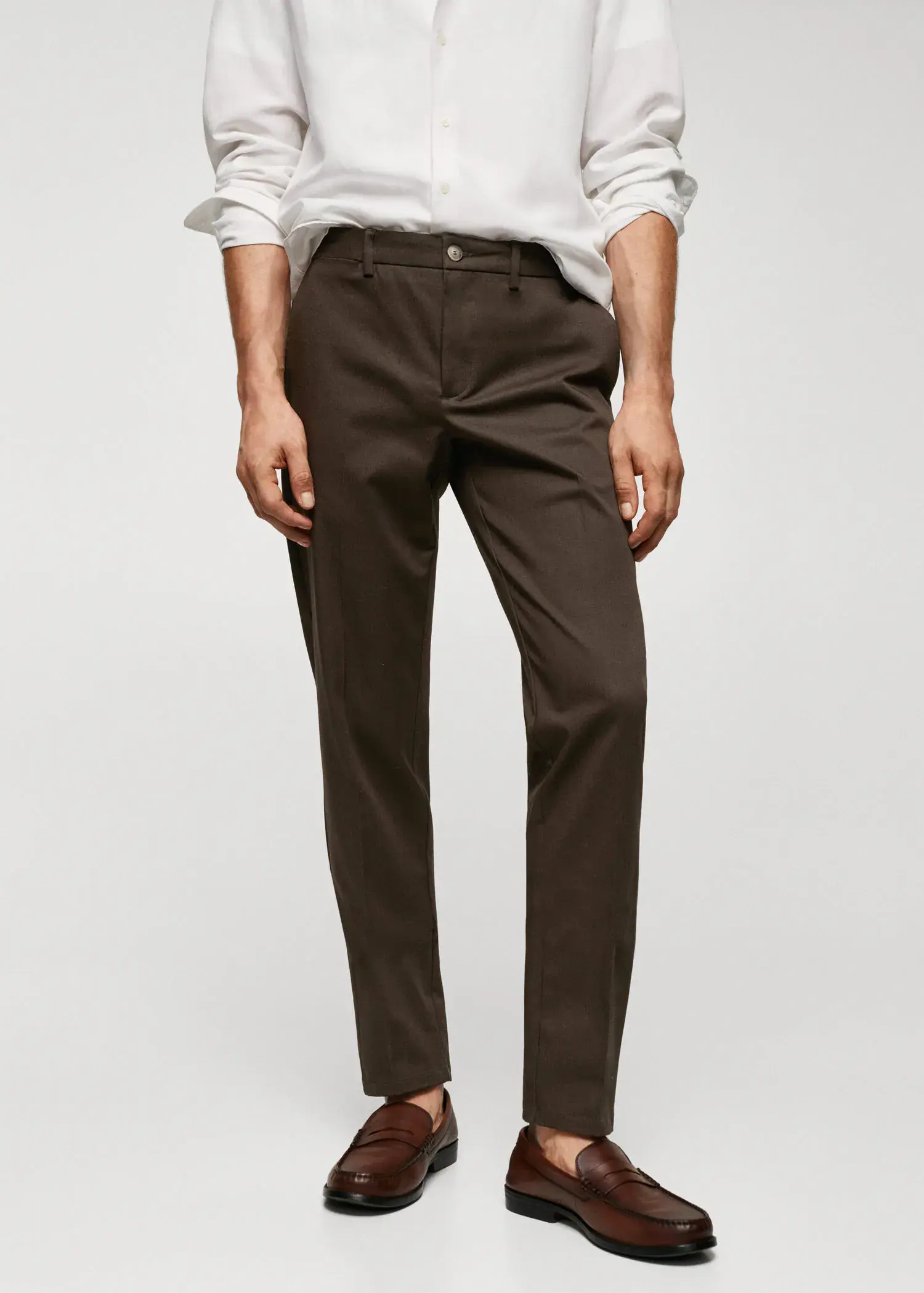 Mango Slim fit chino trousers. a man wearing brown pants and a white shirt. 