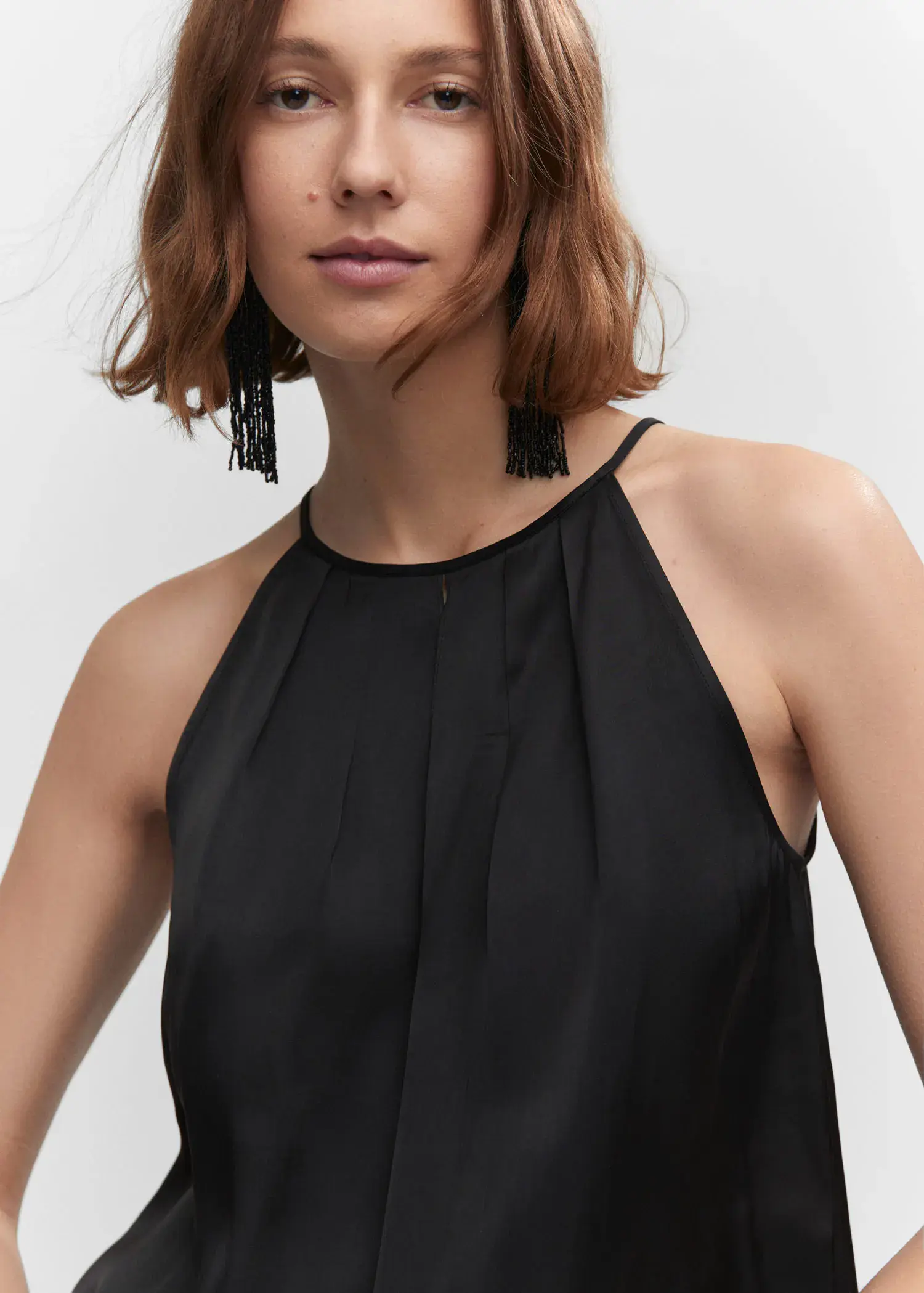 Mango Satin halter-neck top. a close up of a person wearing a black dress 