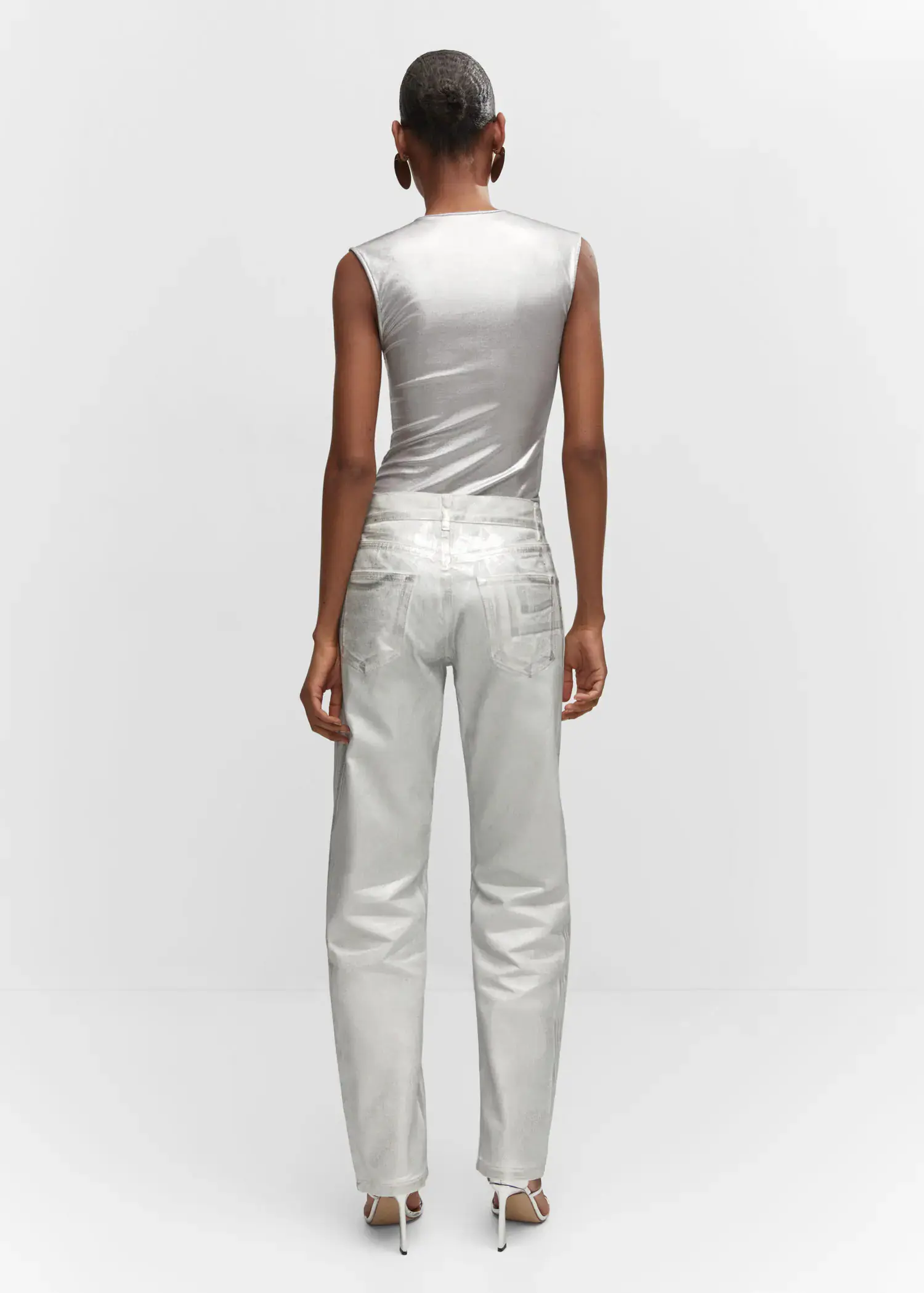 Mango Metallic straight-leg jeans. a woman in a white outfit standing in front of a wall. 