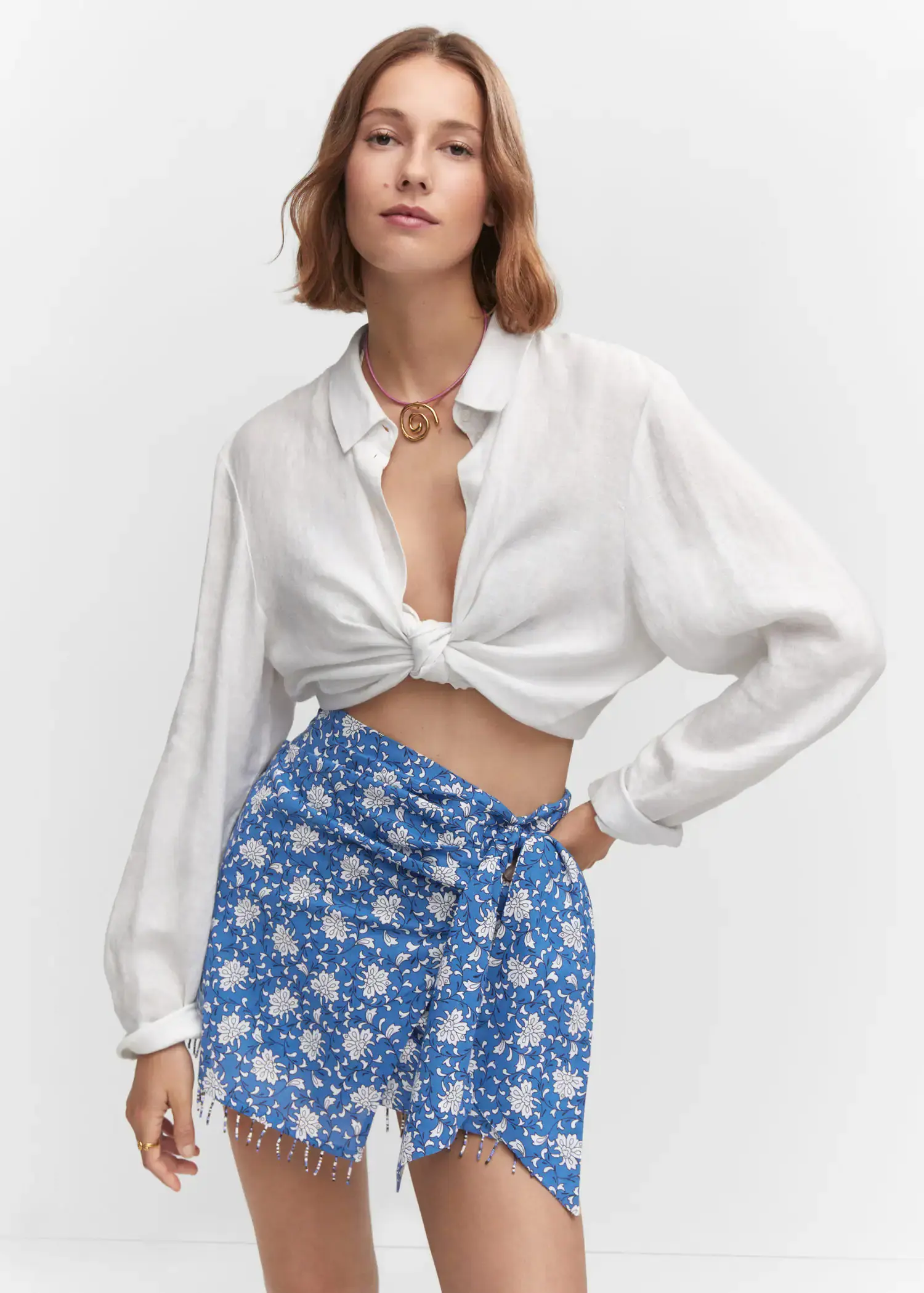 Mango Beaded printed mini-skirt. a woman wearing a white shirt and a blue floral skirt. 