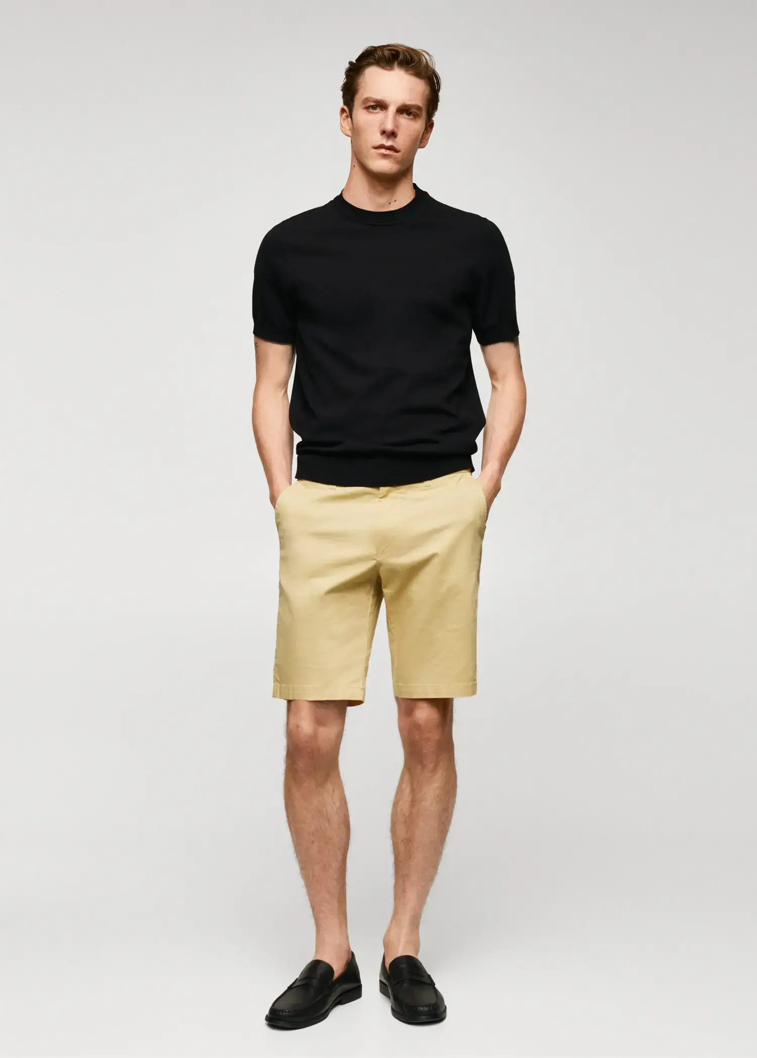 Mango Chino Bermuda shorts. a man in black shirt and beige shorts. 
