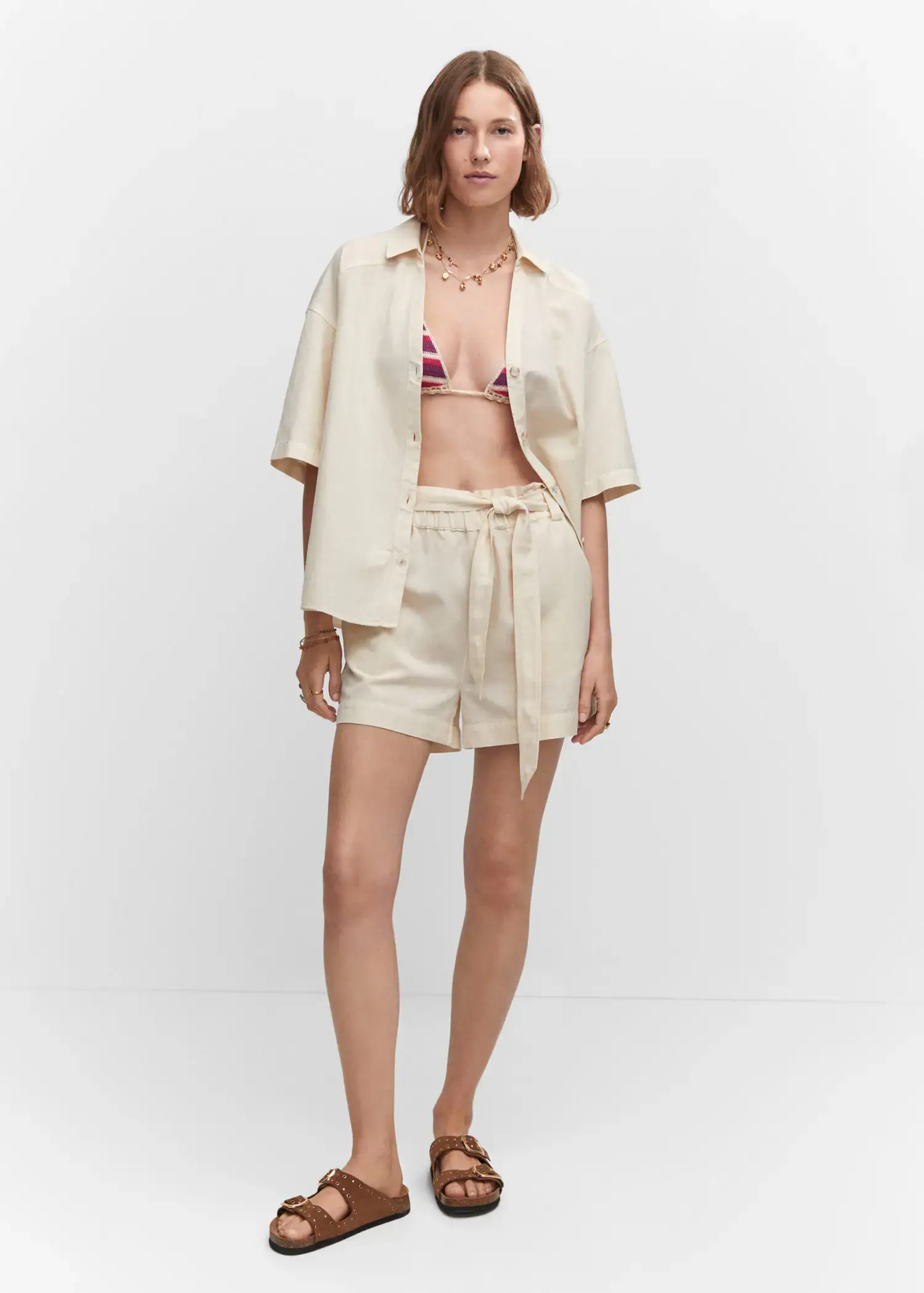 Mango Cotton linen shorts. a woman in a white bathing suit and a white jacket. 