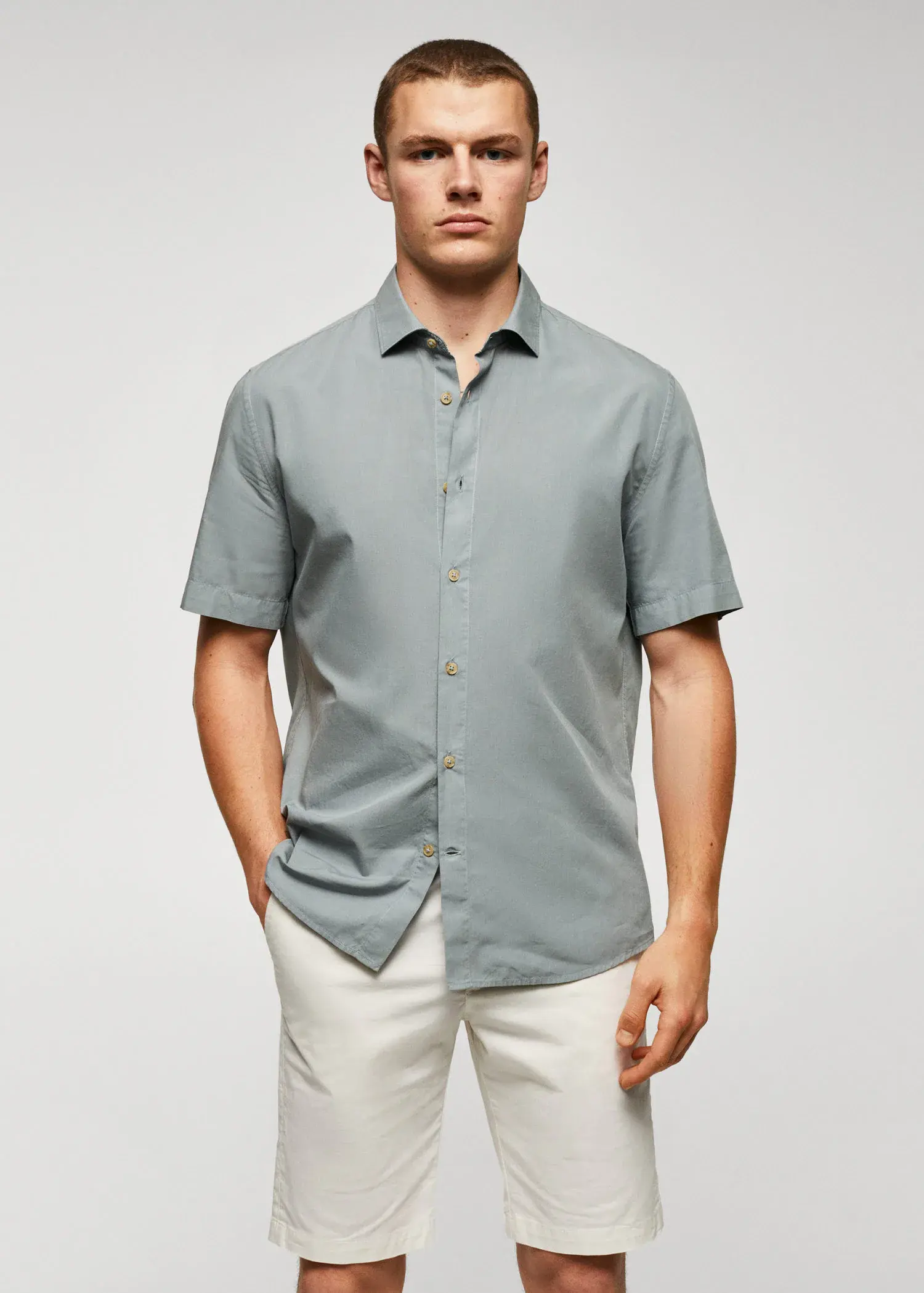 Mango Lightweight cotton shirt . a man wearing a light blue shirt and white pants. 