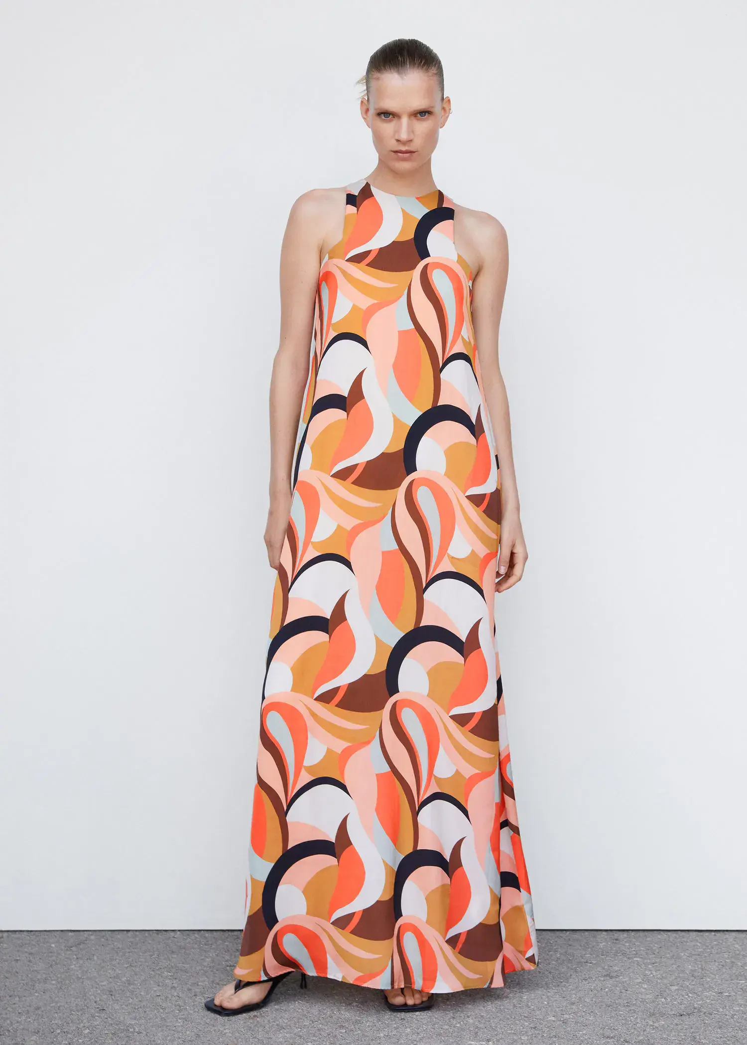 Mango Printed halter gown. a woman standing in front of a white wall wearing a dress. 