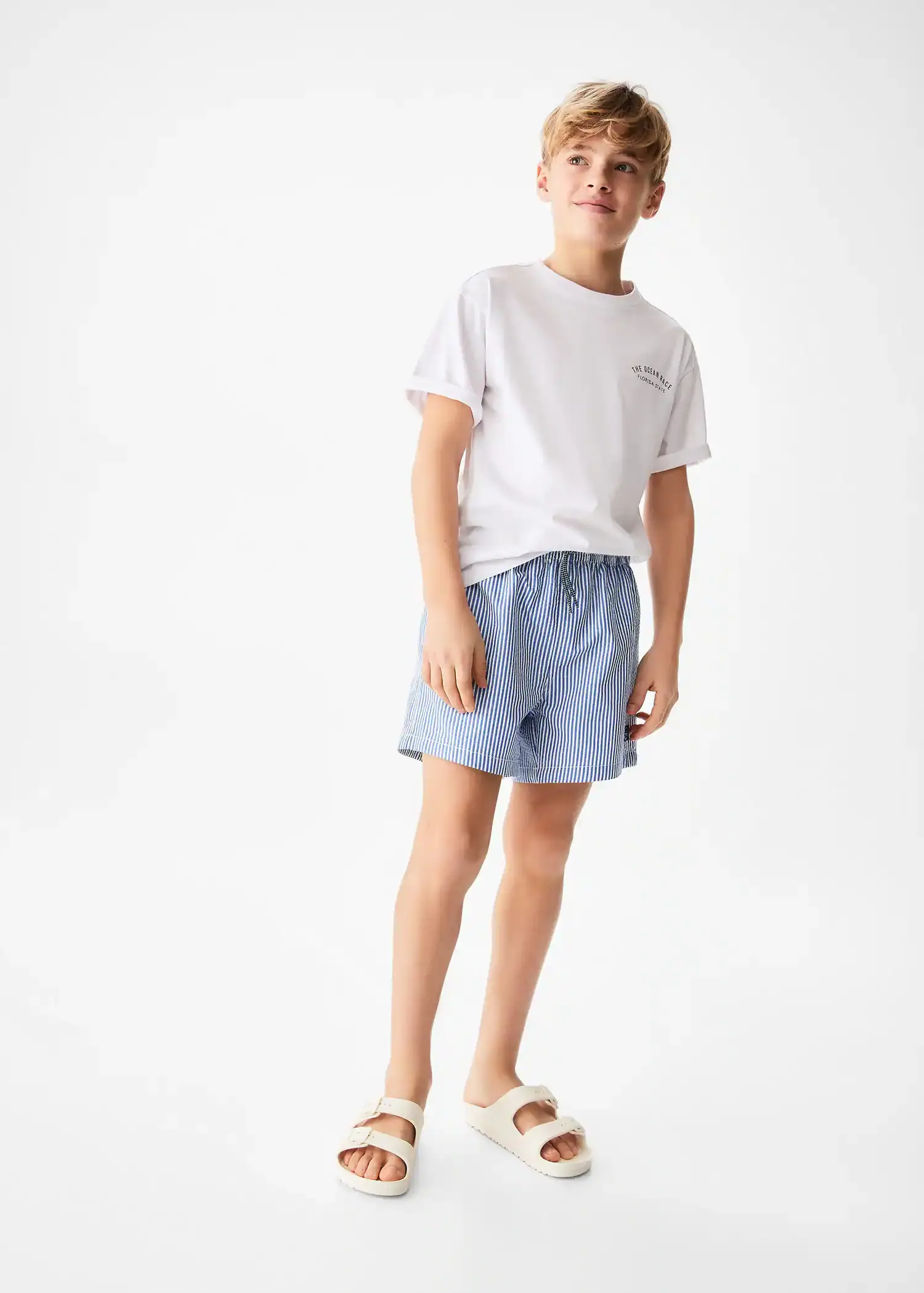Mango KIDS/ Striped swimsuit. a young man in a white t-shirt and light blue shorts. 