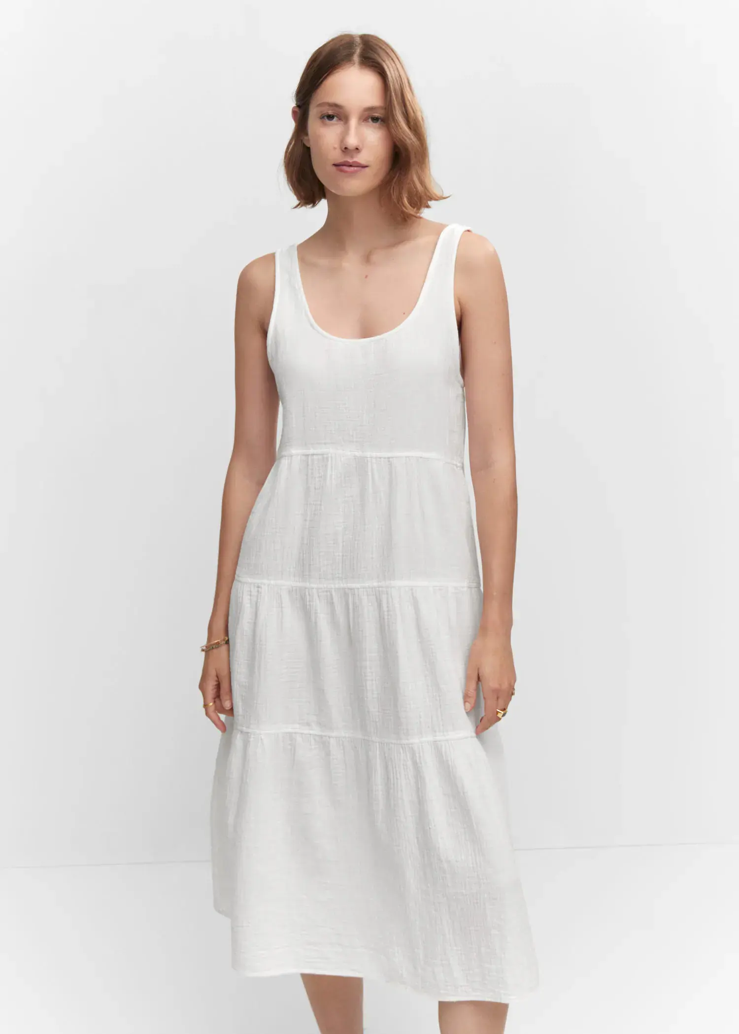 Mango Flared cotton dress. a woman wearing a white dress standing in front of a white wall. 