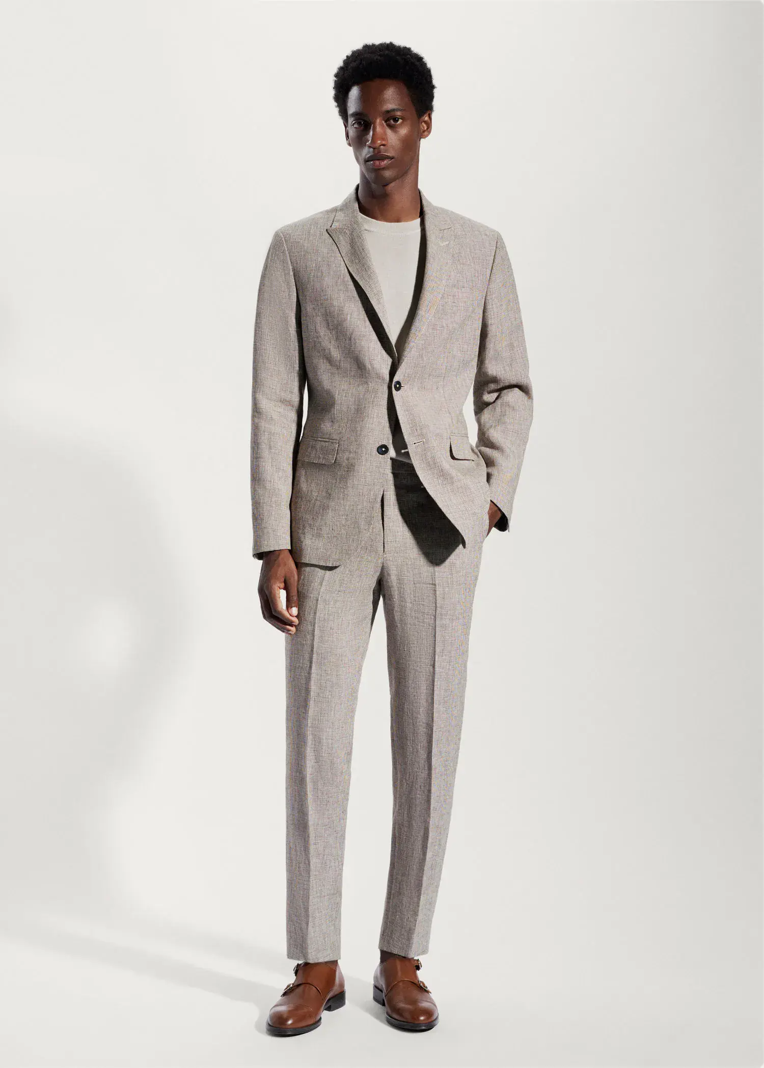Mango Blazer suit 100% linen. a man in a suit standing in front of a white wall. 