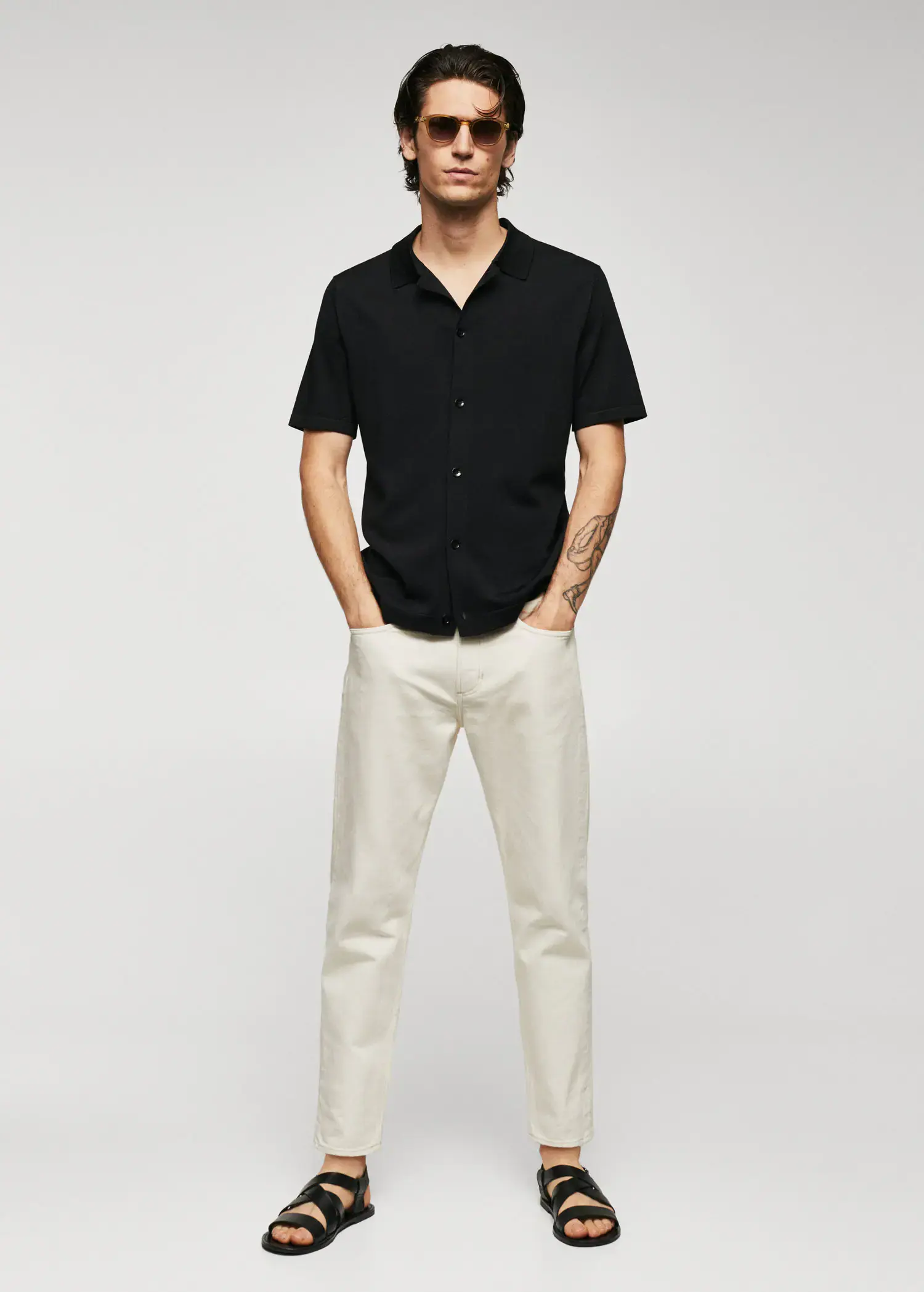 Mango Fine-knit buttoned polo shirt. a man in a black shirt and white pants. 
