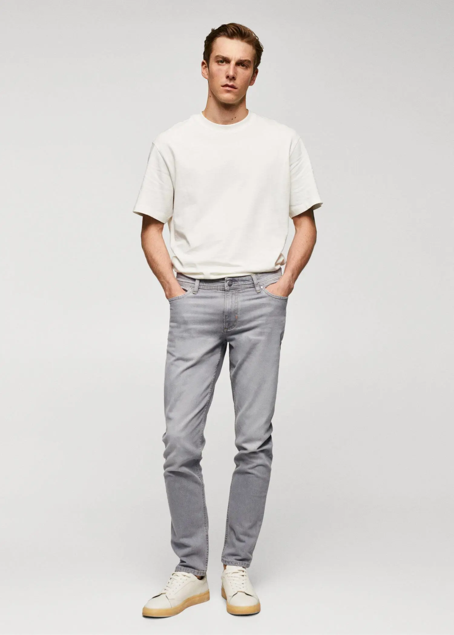 Mango Jan slim-fit jeans. a man standing with his hands in his pockets. 