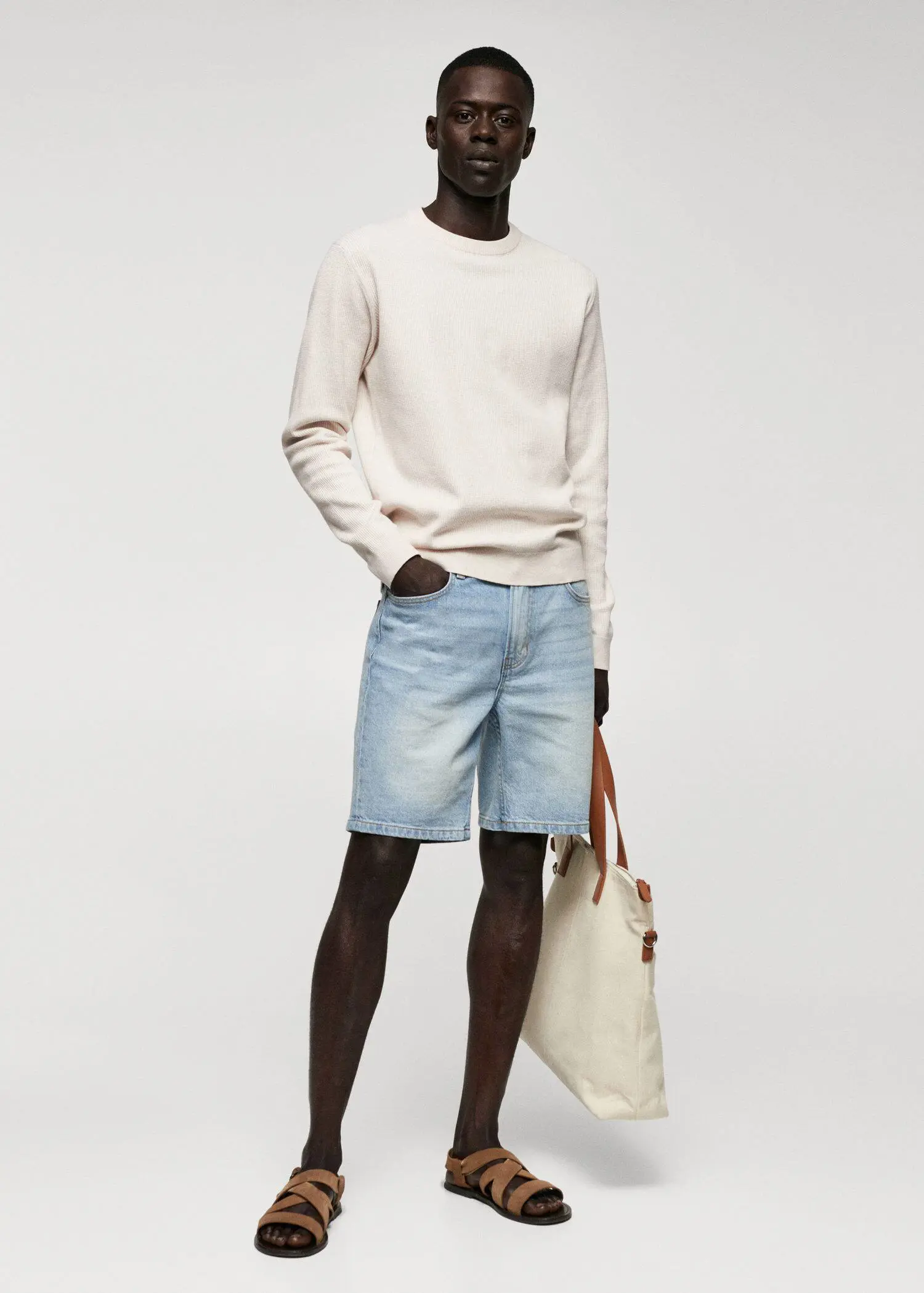 Mango Structured cotton sweater. a man in shorts and a sweater holding a bag. 