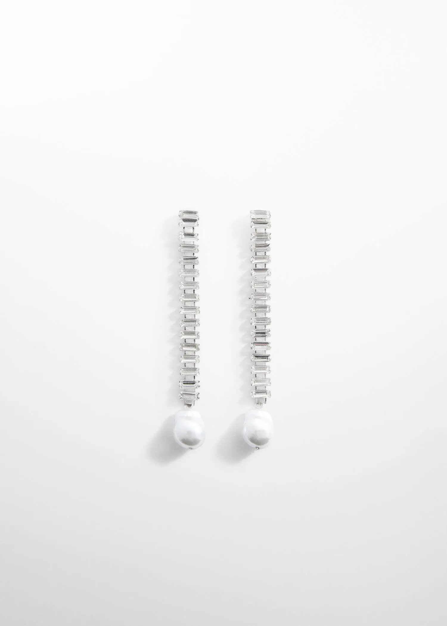 Mango Long pearl earrings. a pair of long white earrings on top of a white surface. 