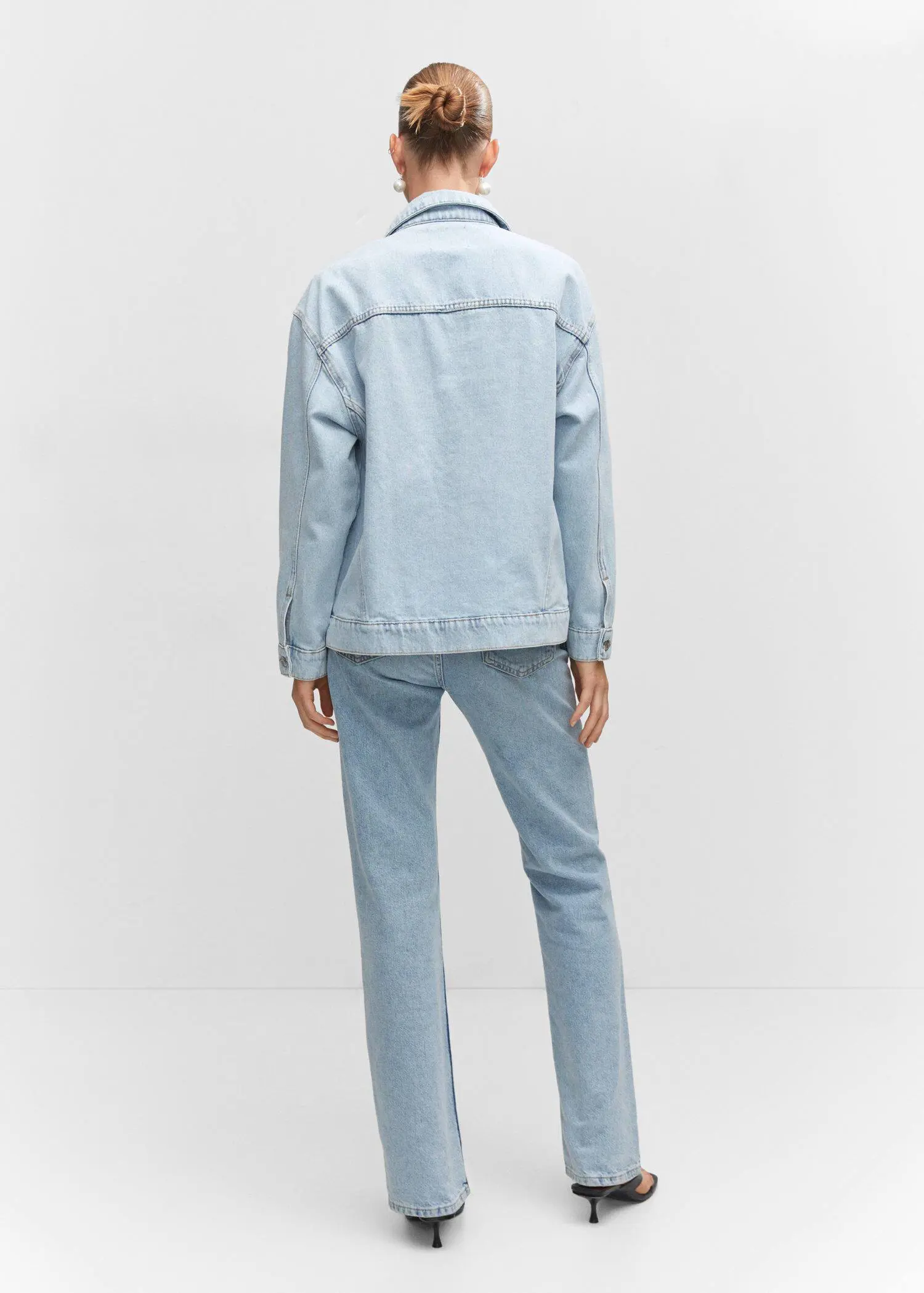 Mango Oversize denim jacket. a person standing in front of a white wall. 