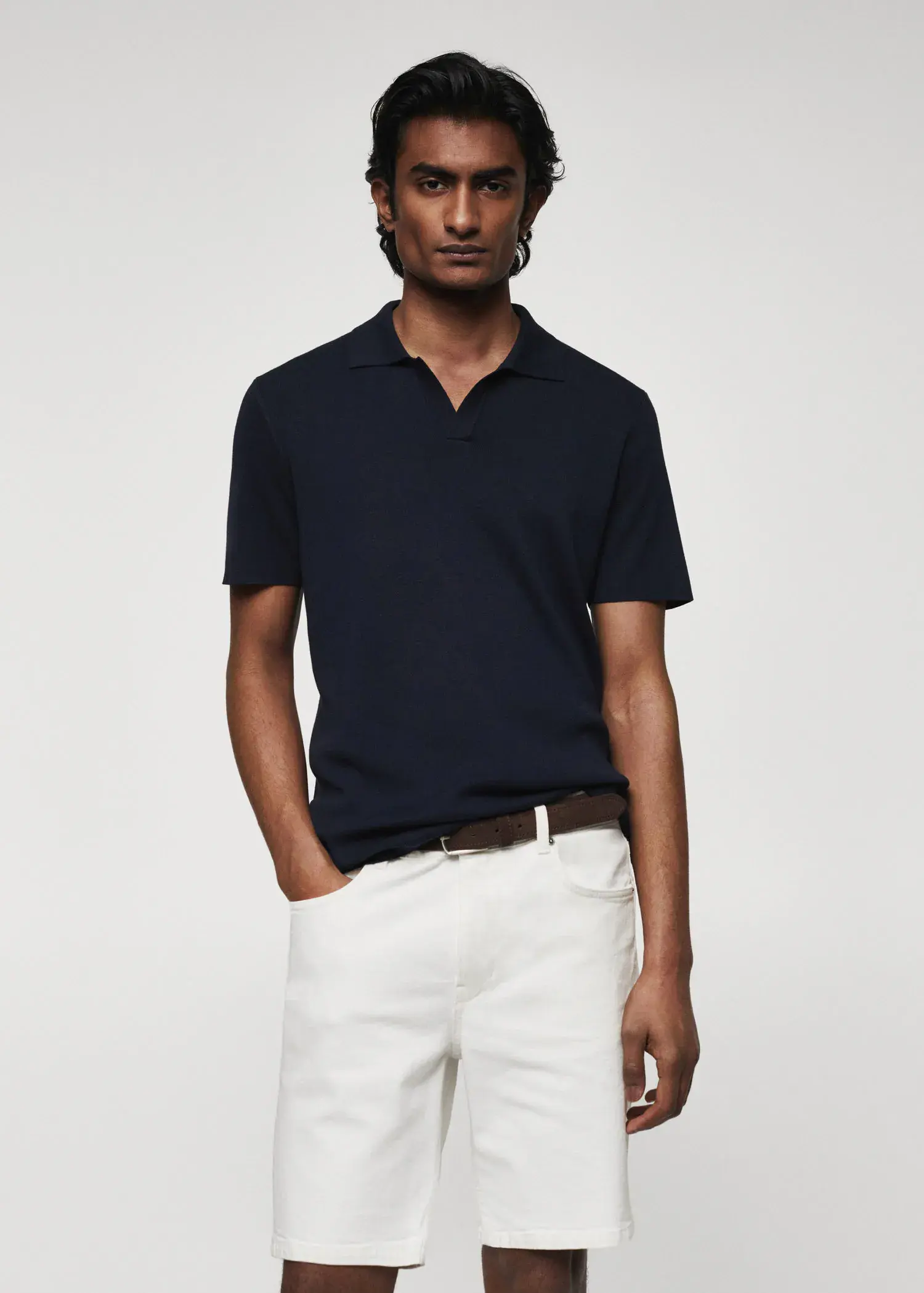 Mango Fine-knit polo shirt. a man in a black polo shirt and white shorts. 