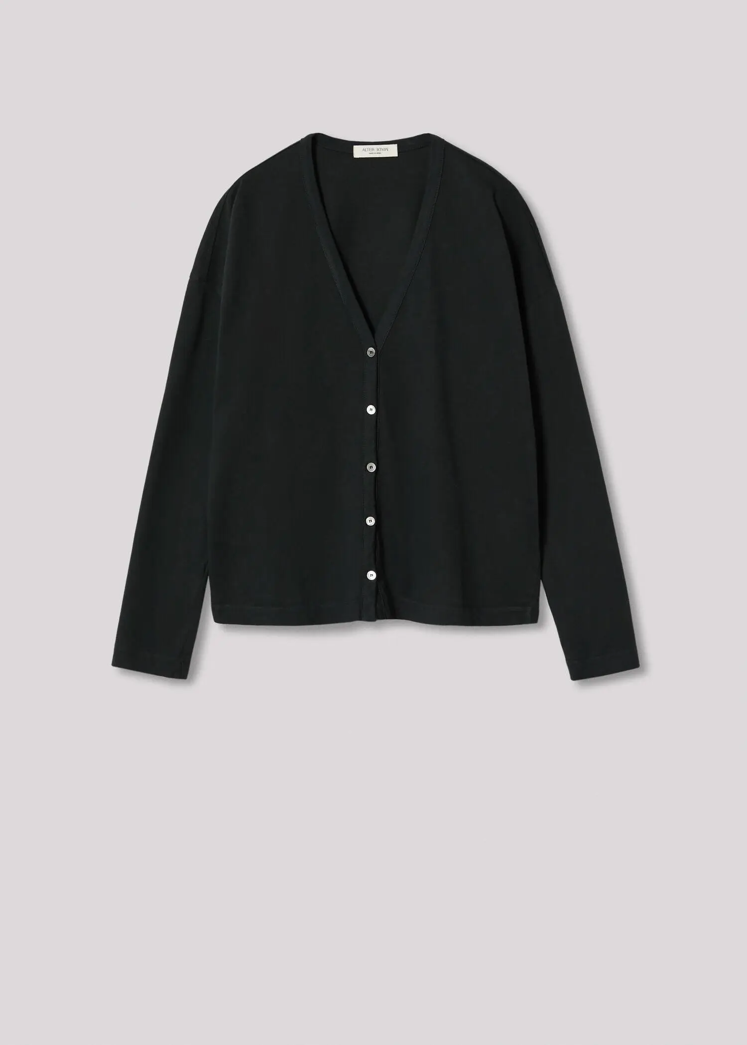 Mango  Hecho en España. a woman wearing a black cardigan with buttons down the front 
