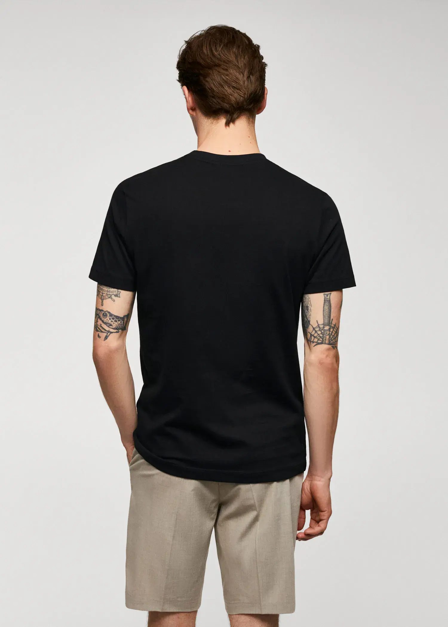 Mango Basic cotton stretch T-shirt. a man wearing a black t-shirt and a pair of brown pants. 