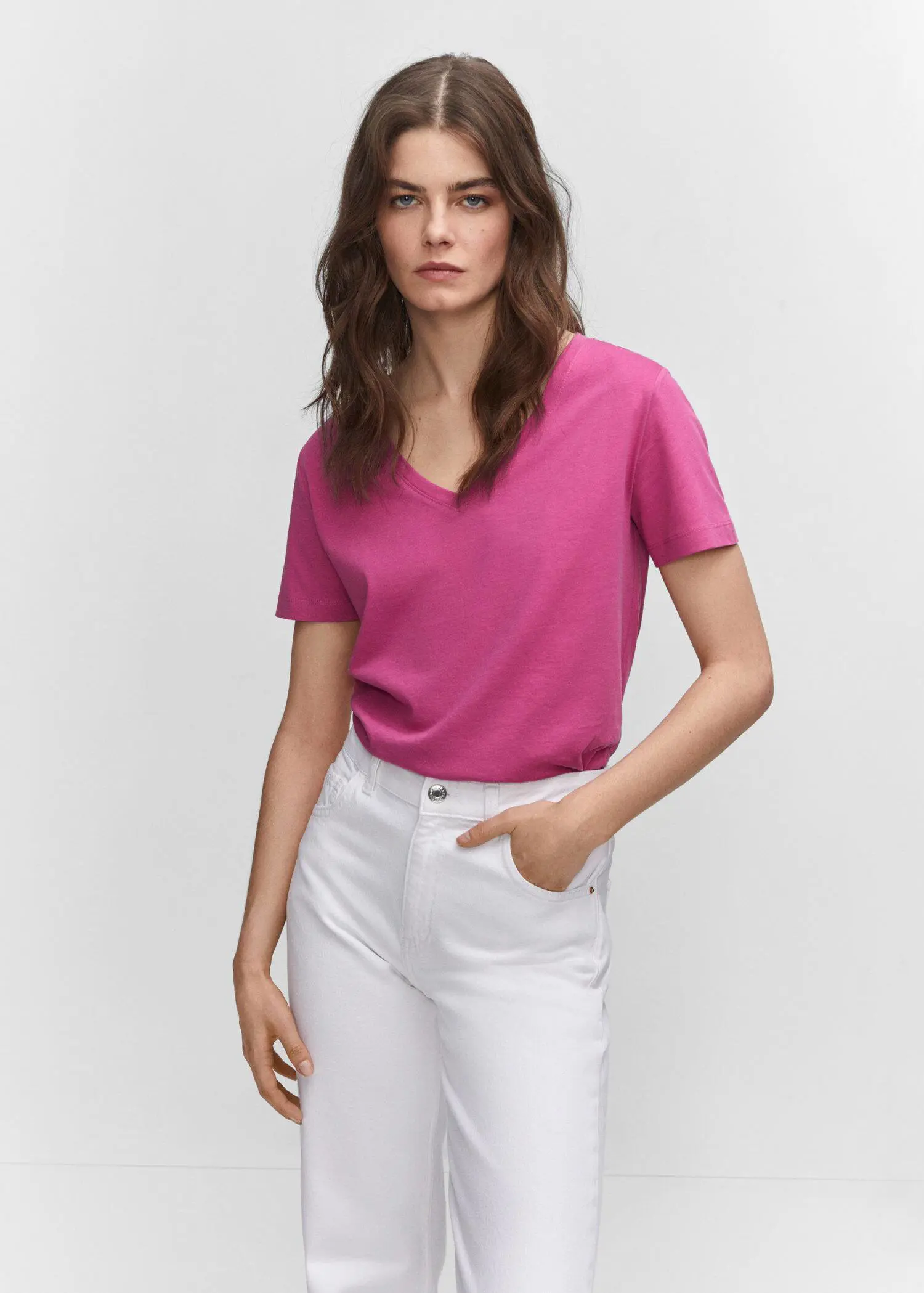 Mango V-neck cotton T-shirt. a woman wearing white pants and a pink top. 