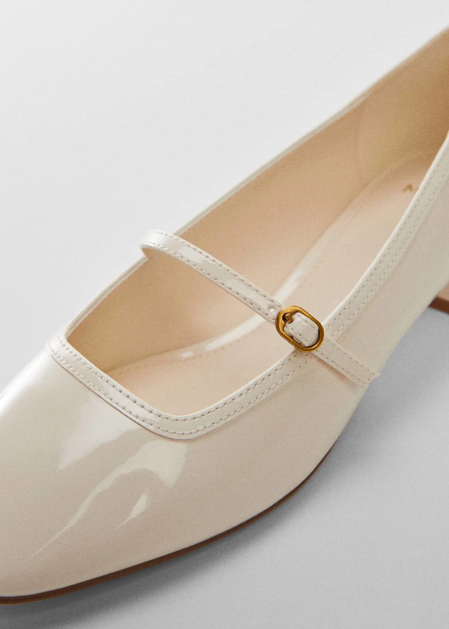 Mango Buckle heel shoes. a close-up of a pair of white shoes. 