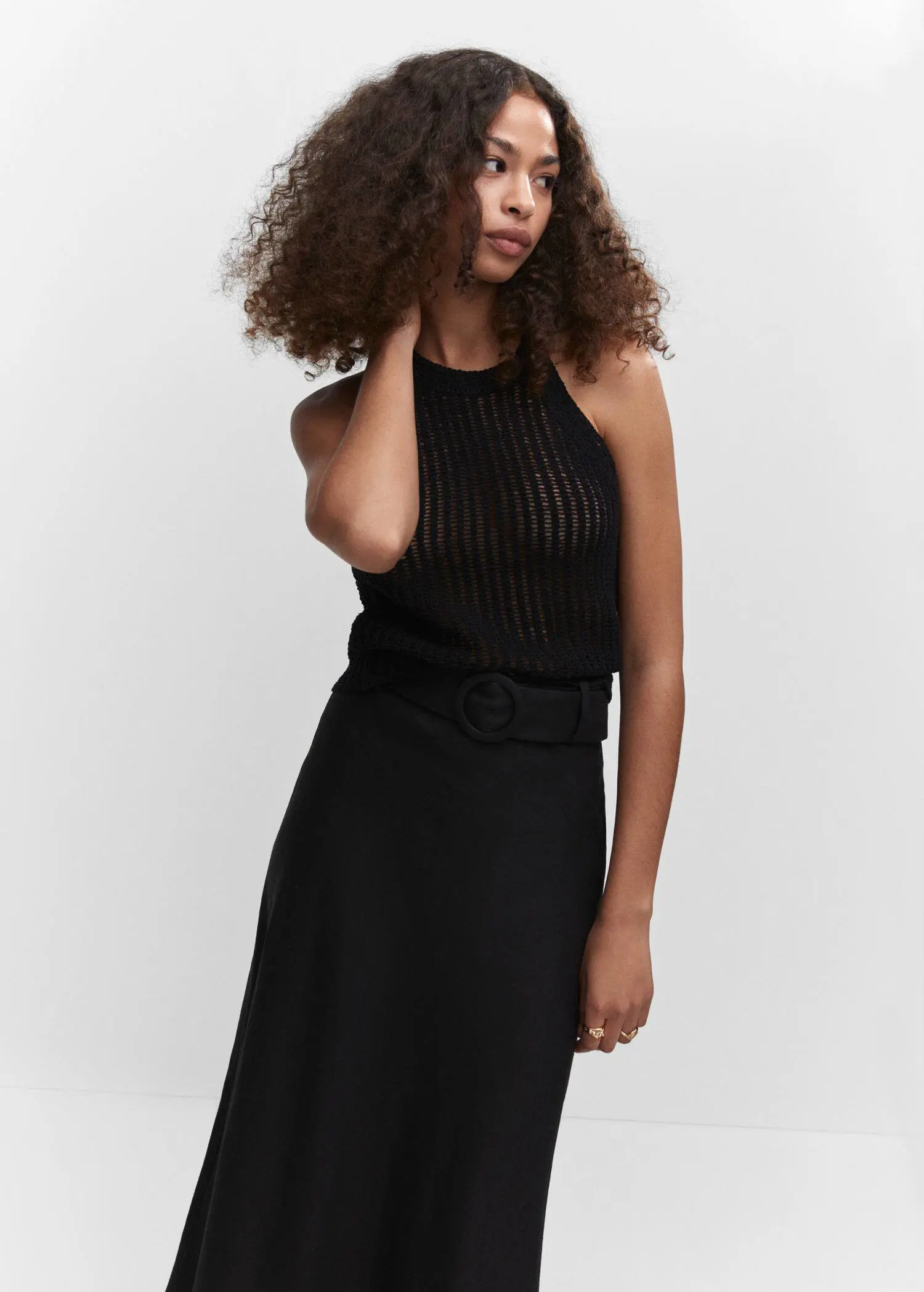 Mango Halter-neck knitted top. a woman in a black dress is posing. 