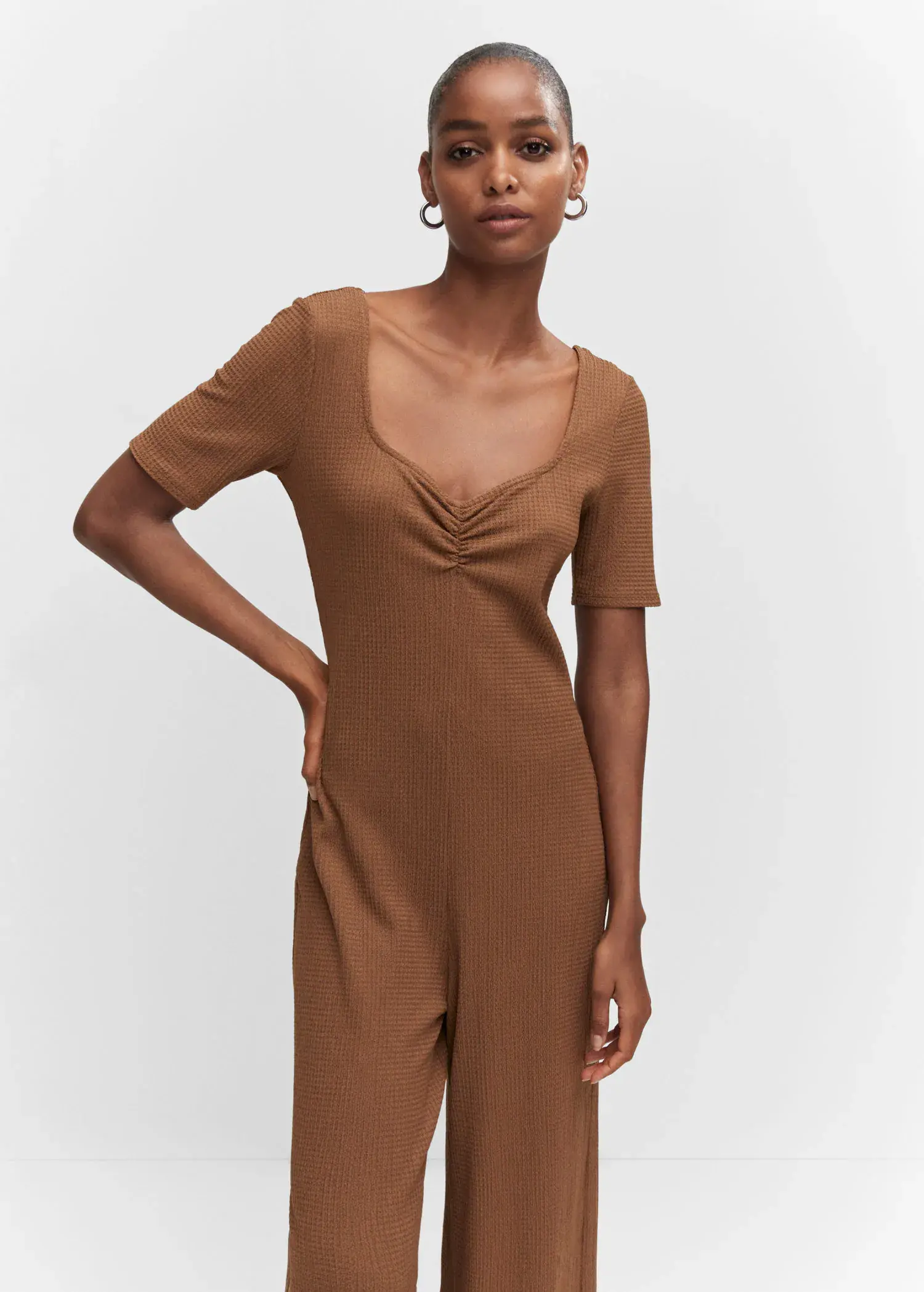 Mango Ruched long jumpsuit. a woman wearing a brown jumpsuit posing for a picture. 