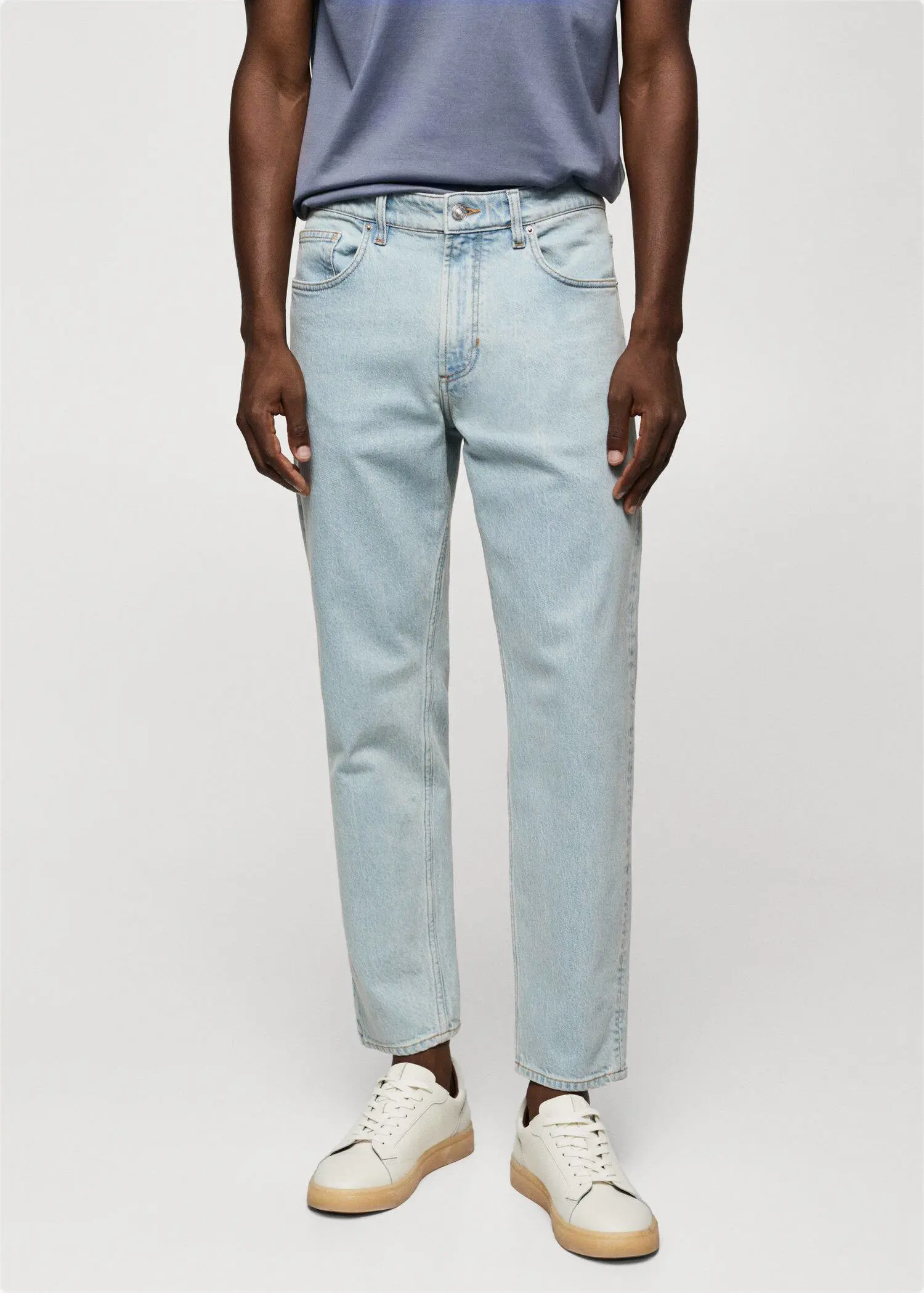 Mango Ben tapered cropped jeans. a man wearing light blue jeans and white sneakers. 
