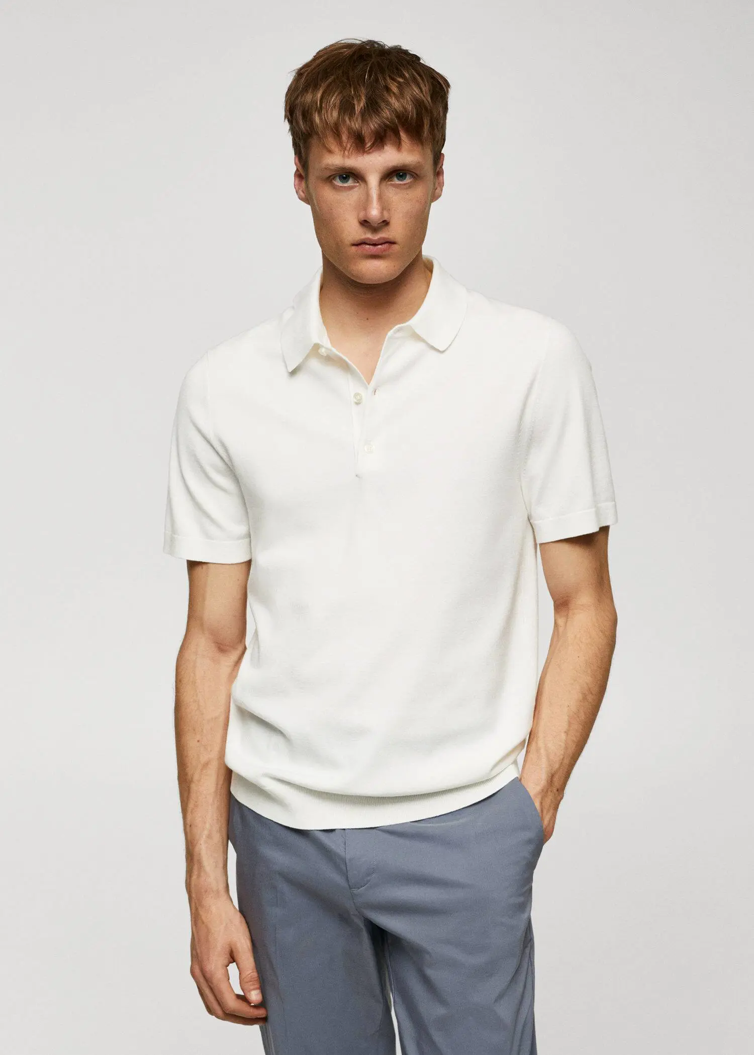 Mango Fine-knit polo shirt. a man in a white shirt is standing with his hands in his pockets. 