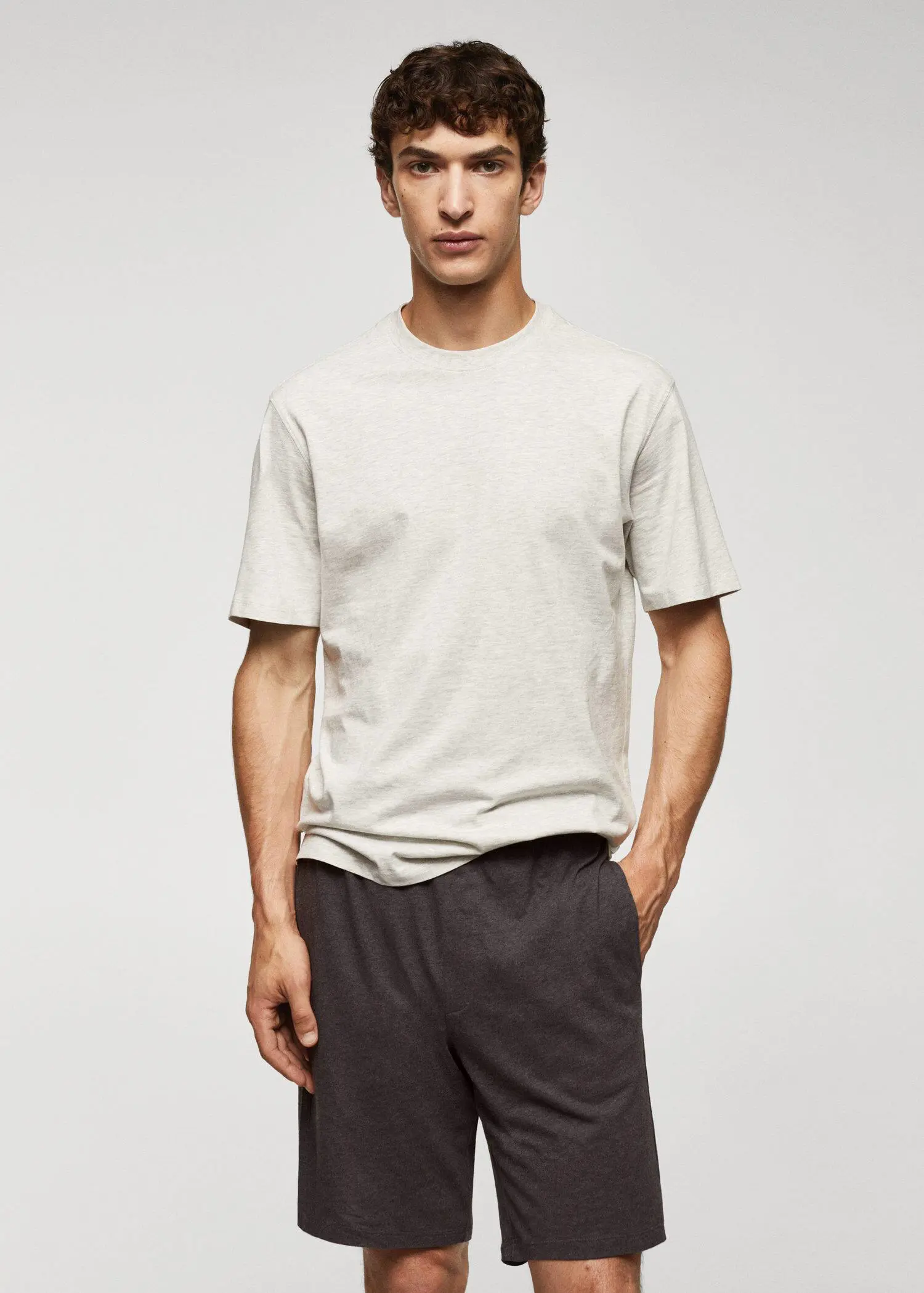 Mango Cotton pajama shorts pack. a man in a white t-shirt is standing with his hands in his pockets 