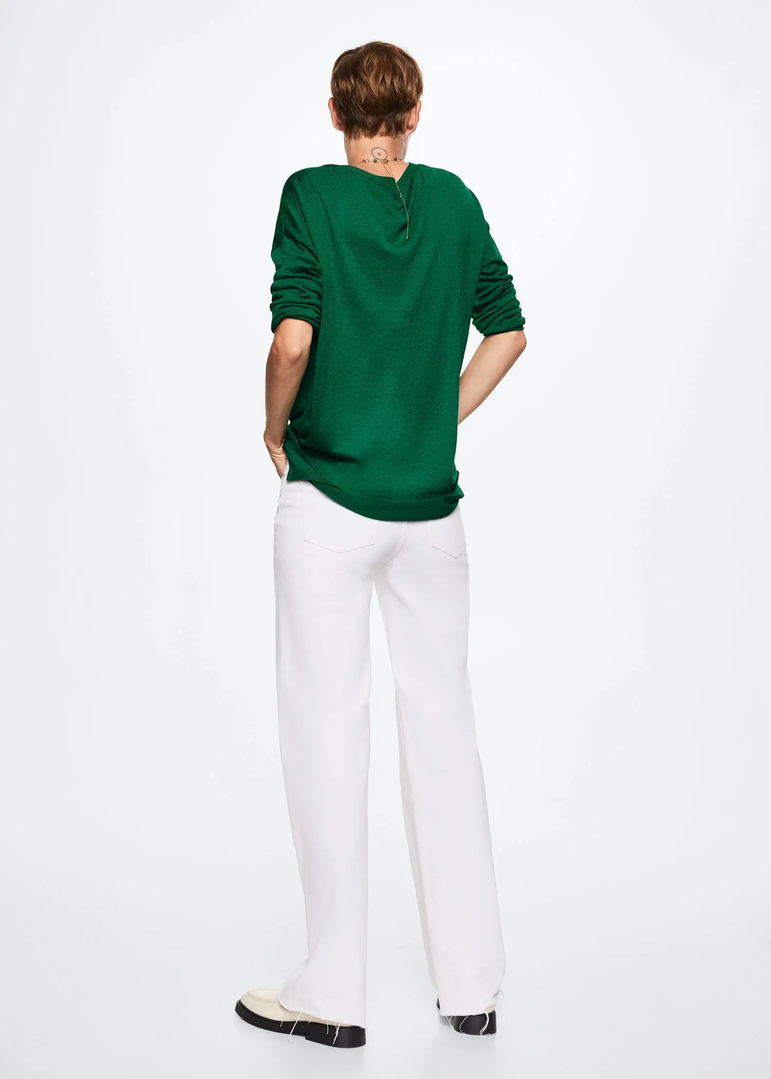 Mango V-neck knit sweater. a woman wearing a green shirt and white pants. 
