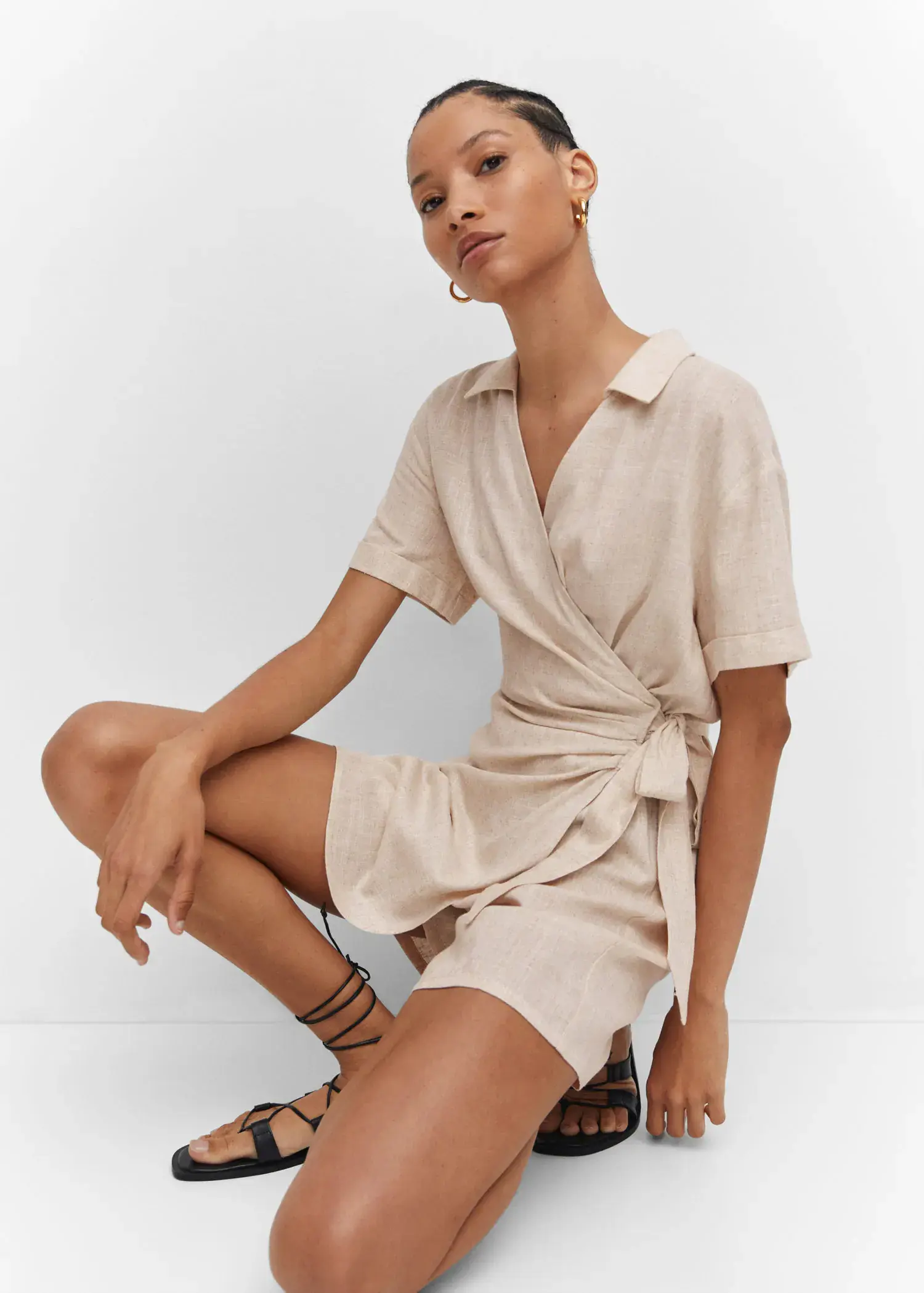Mango Bow wrap jumpsuit. a woman sitting on the ground wearing a dress. 