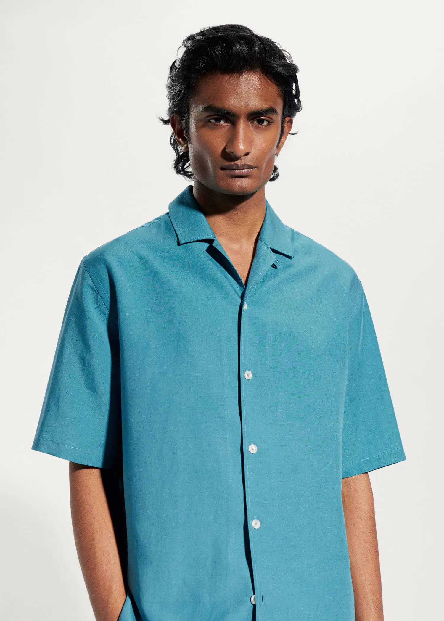 Mango Regular-fit linen bowling shirt. a man in a blue shirt is posing for a picture. 