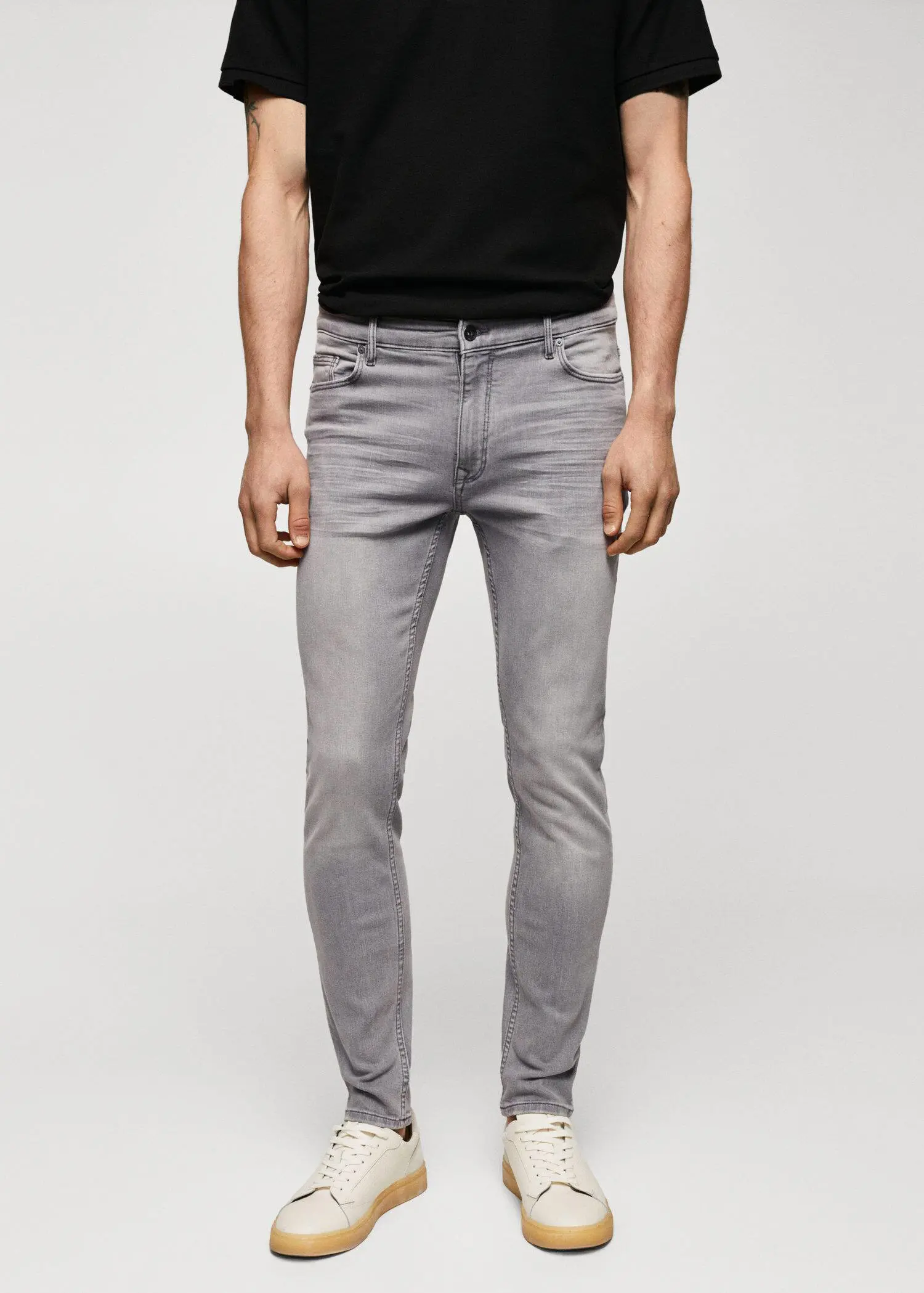 Mango Jude skinny-fit jeans. a man wearing a black t-shirt and gray jeans. 