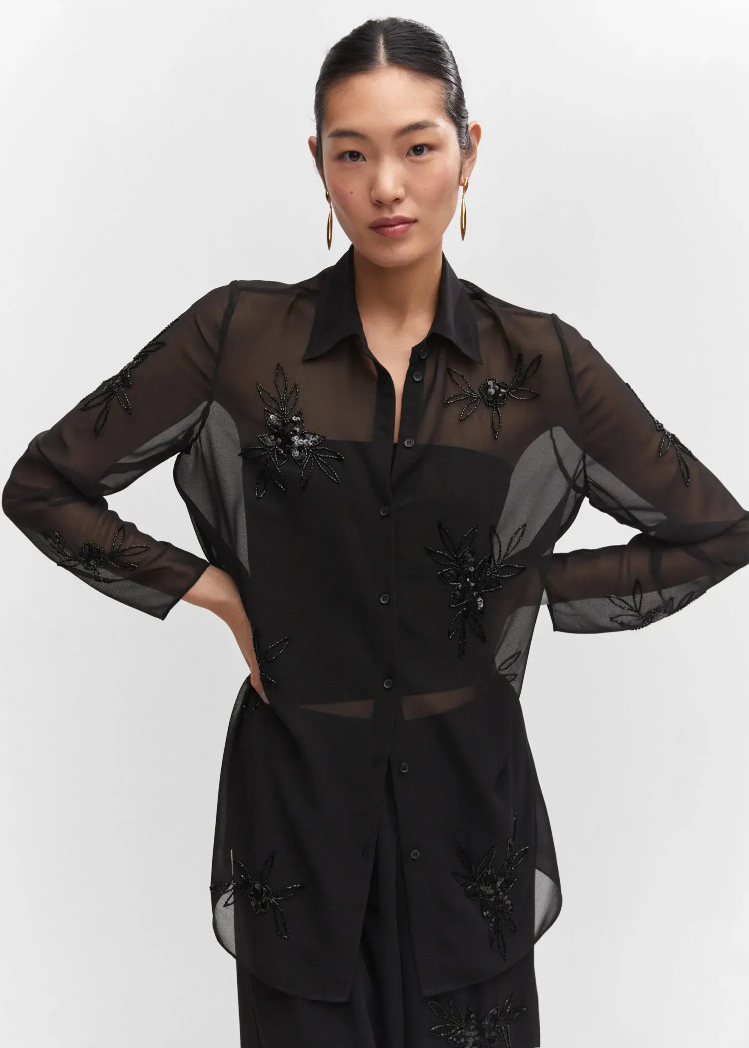 Mango Shirt with bead detail. a woman in a black shirt is posing. 