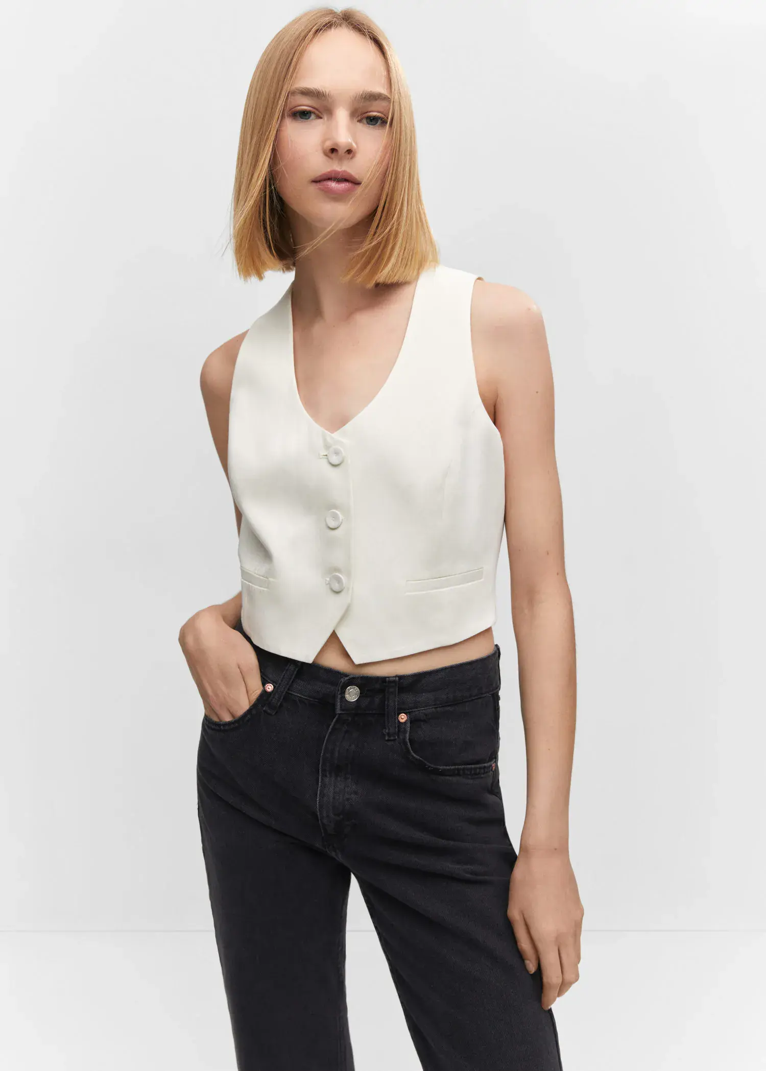Mango Fitted gilet with buttons. a woman wearing a white vest and black jeans. 