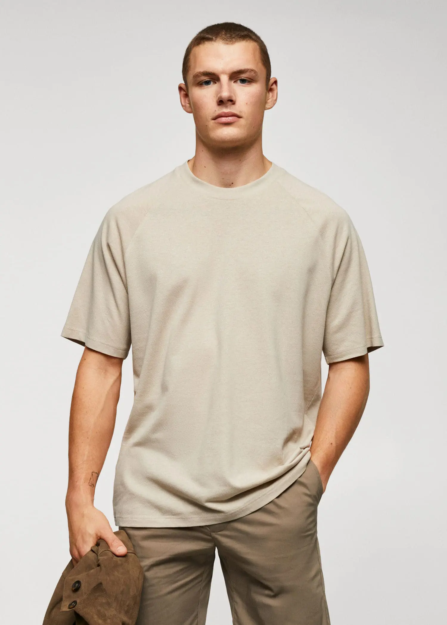 Mango Textured cotton-linen t-shirt. a young man wearing a beige t-shirt. 