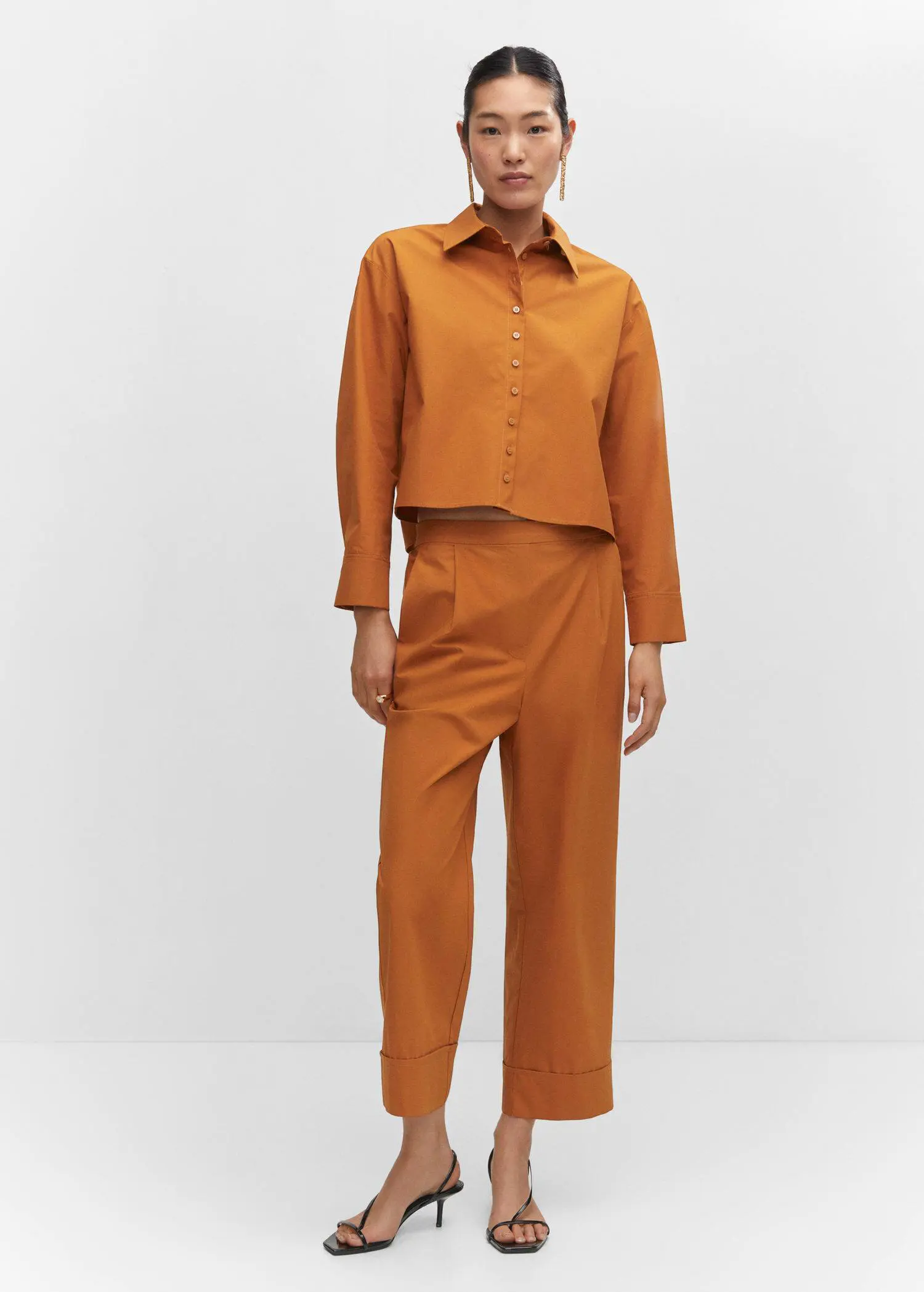 Mango Pleated culottes pants. a person standing in a room wearing a suit. 